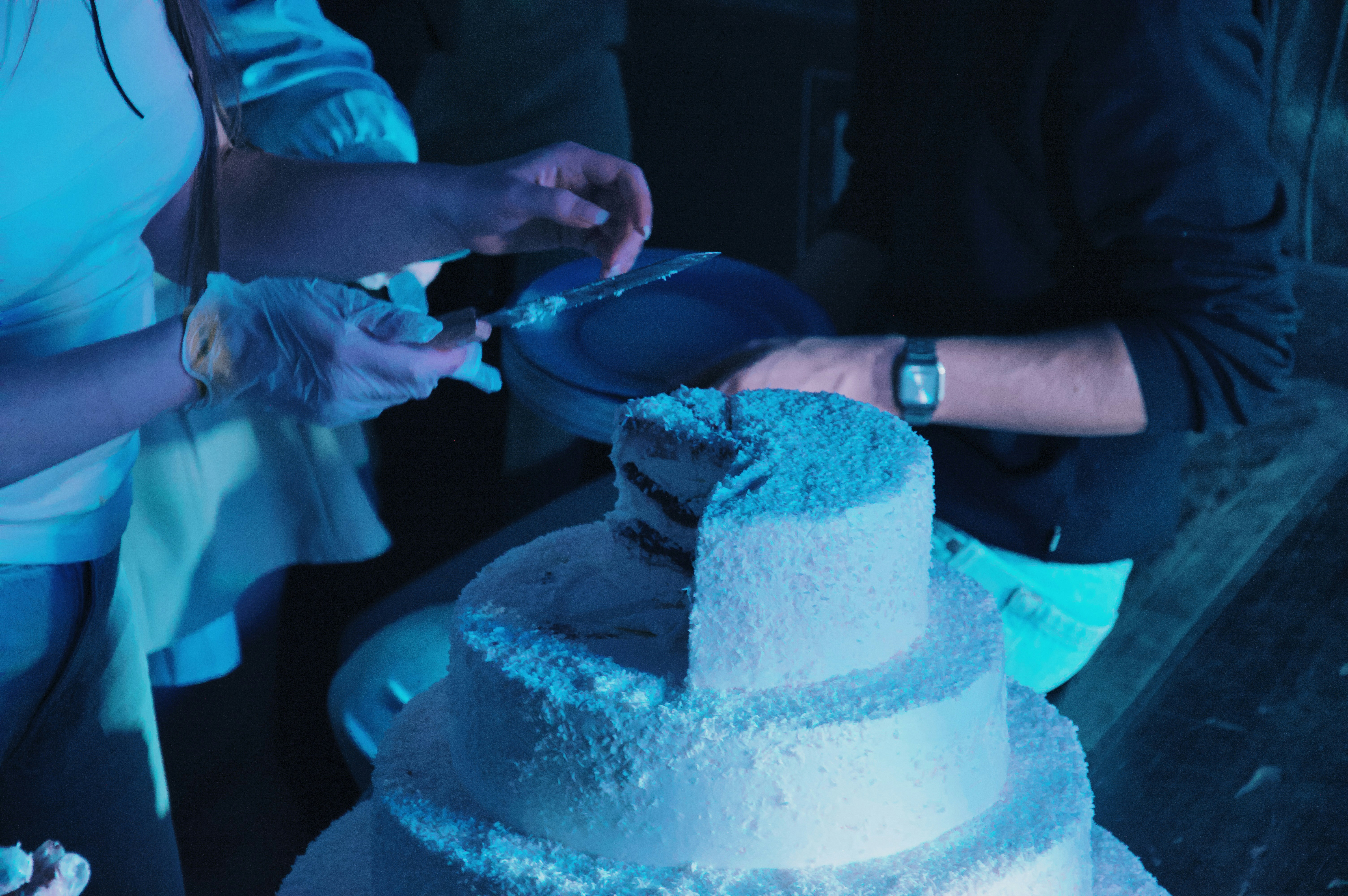 Person cutting tiered coconut cake - Free Photo on Unsplash