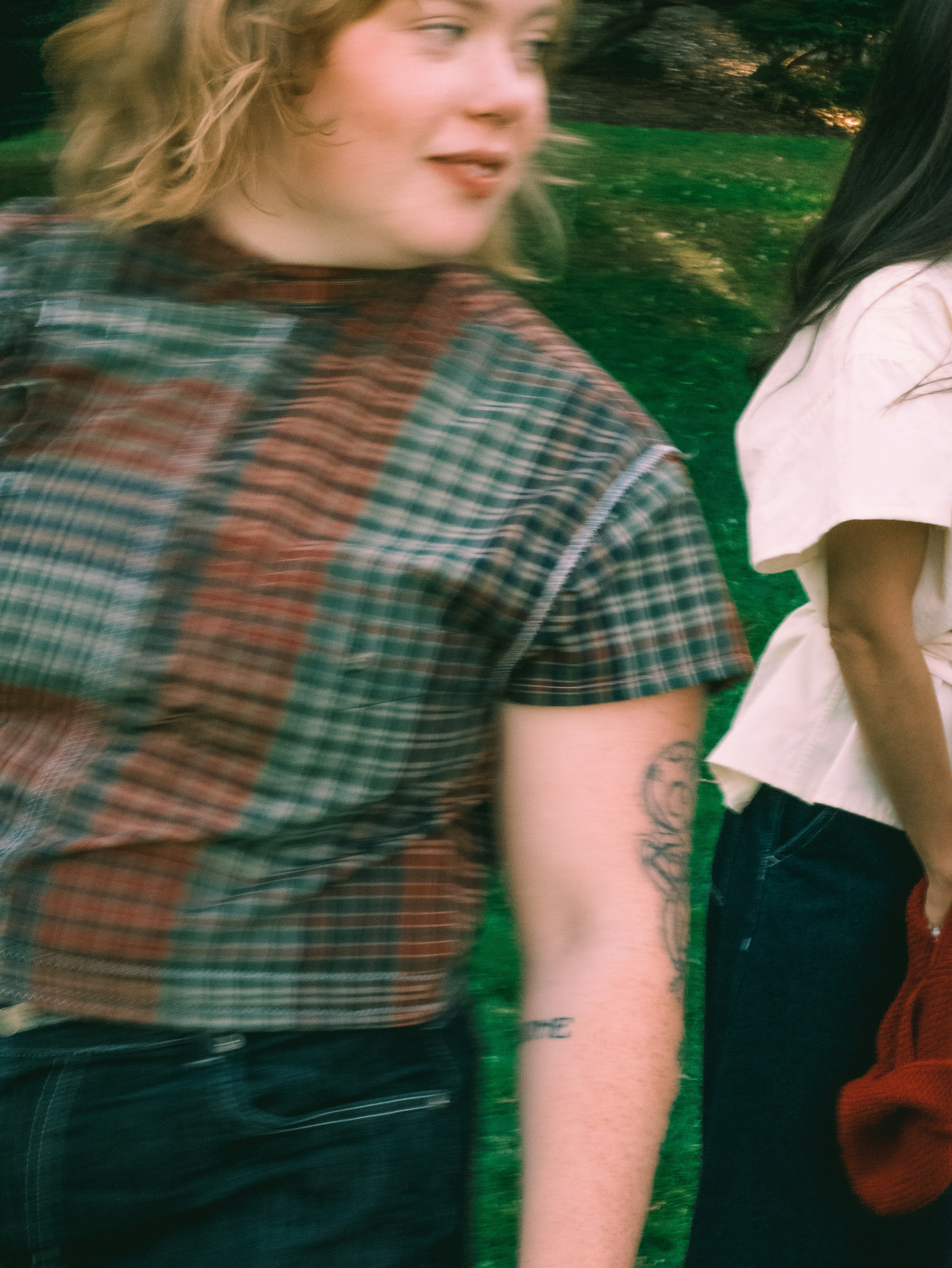 Two people walking outdoors in a park with motion blur