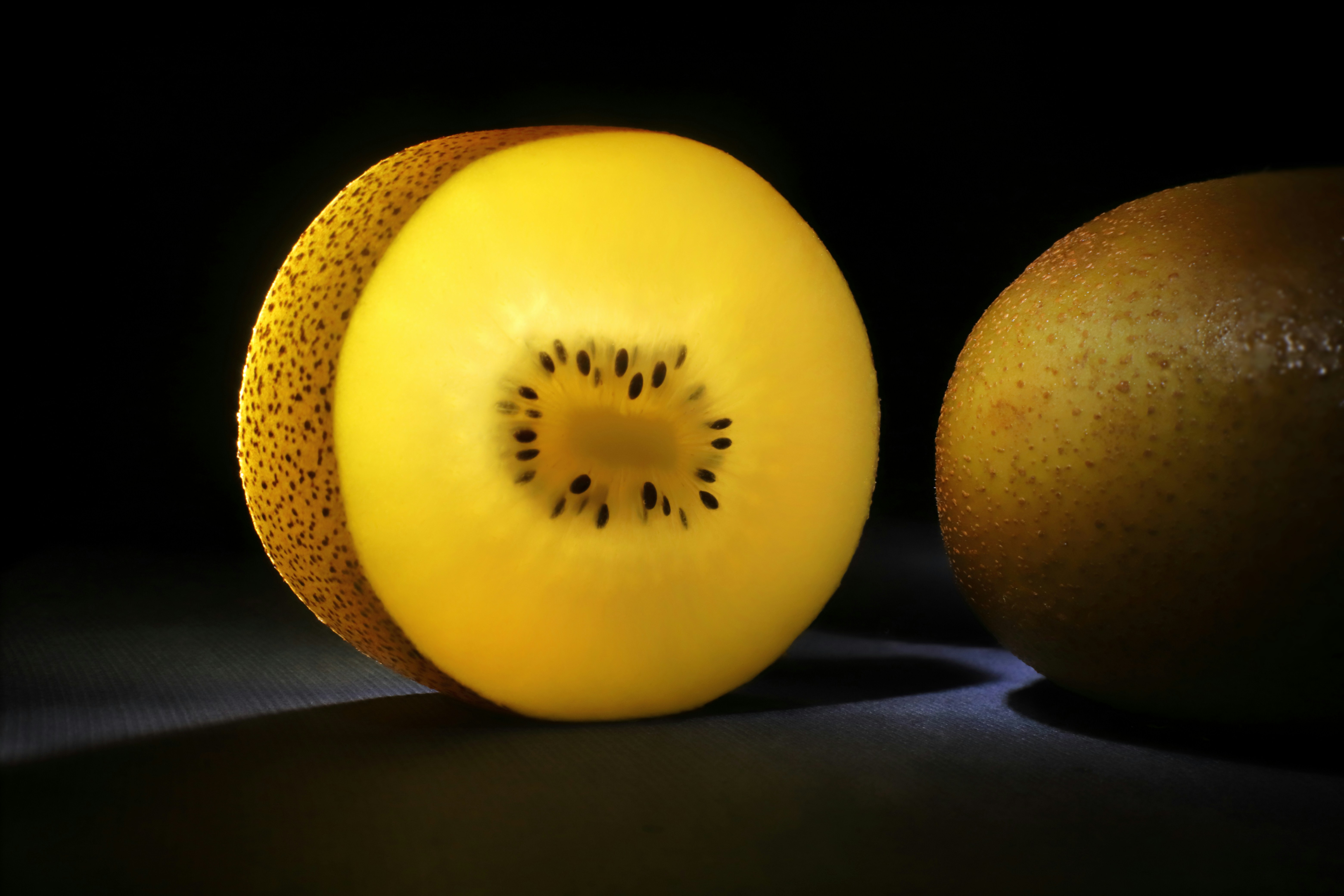 Halved golden kiwi on dark surface - Free Photo on Unsplash