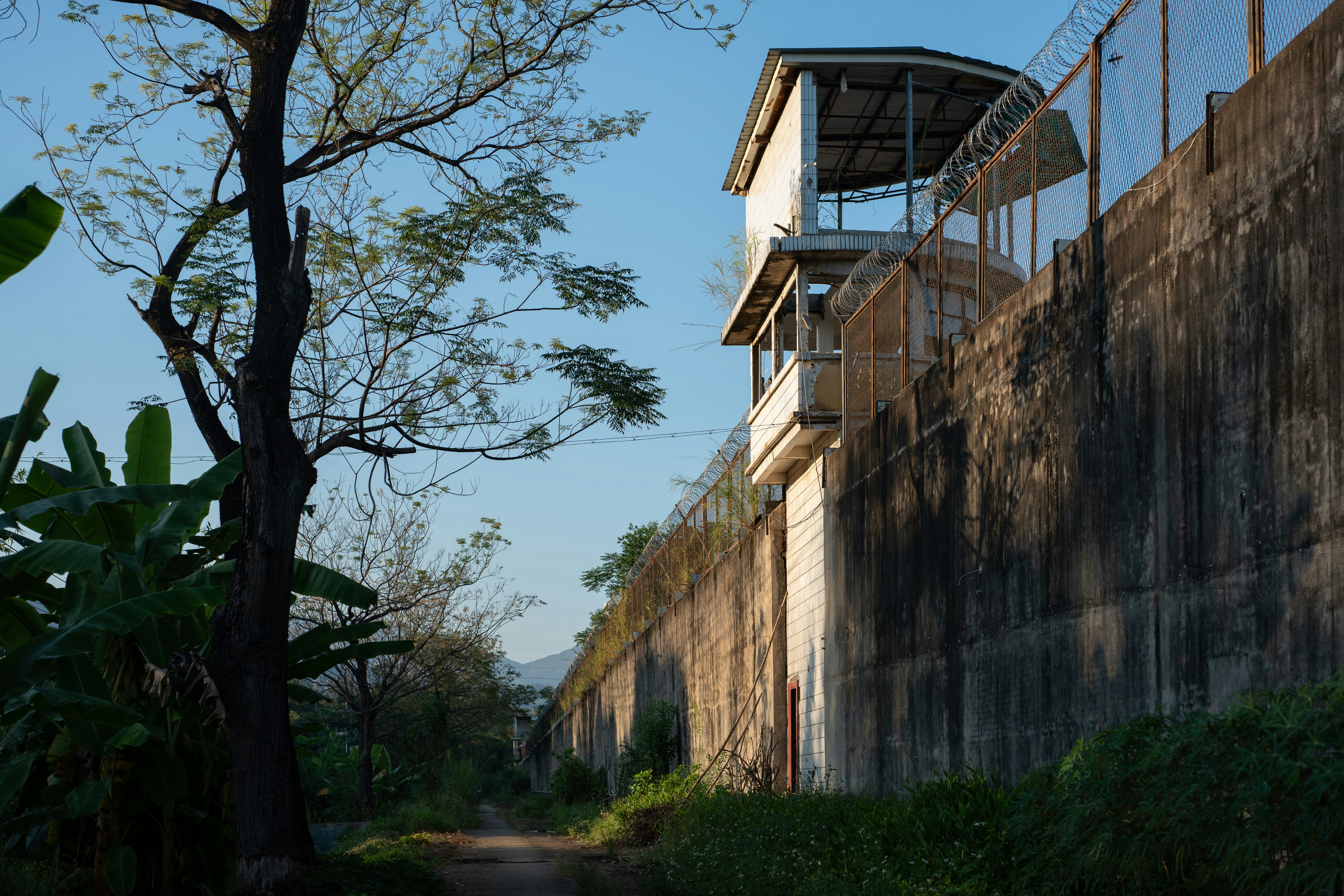 Concrete prison wall with guard tower - Free Photo on Unsplash