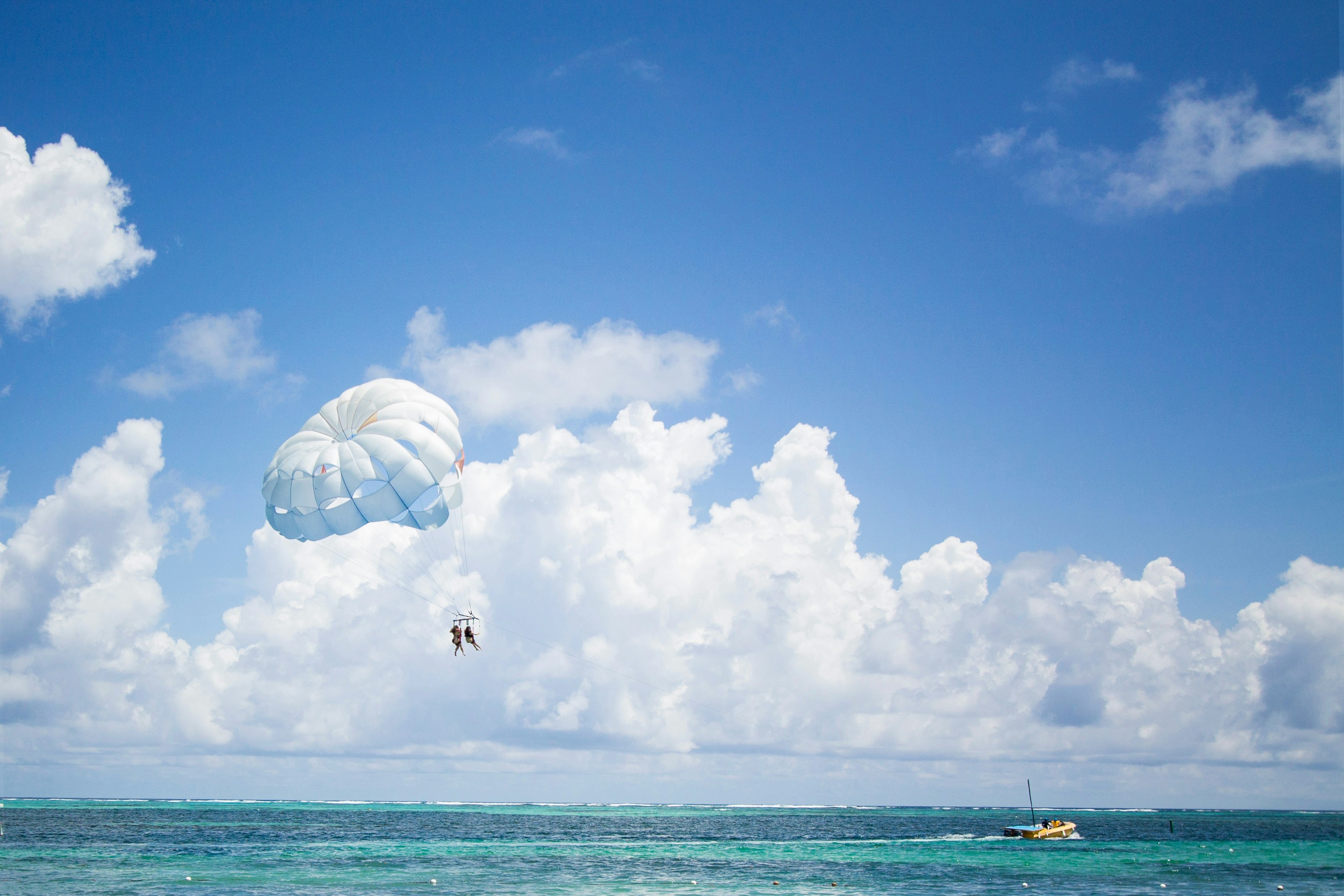 Parasailing over blue ocean water - Free Photo on Unsplash