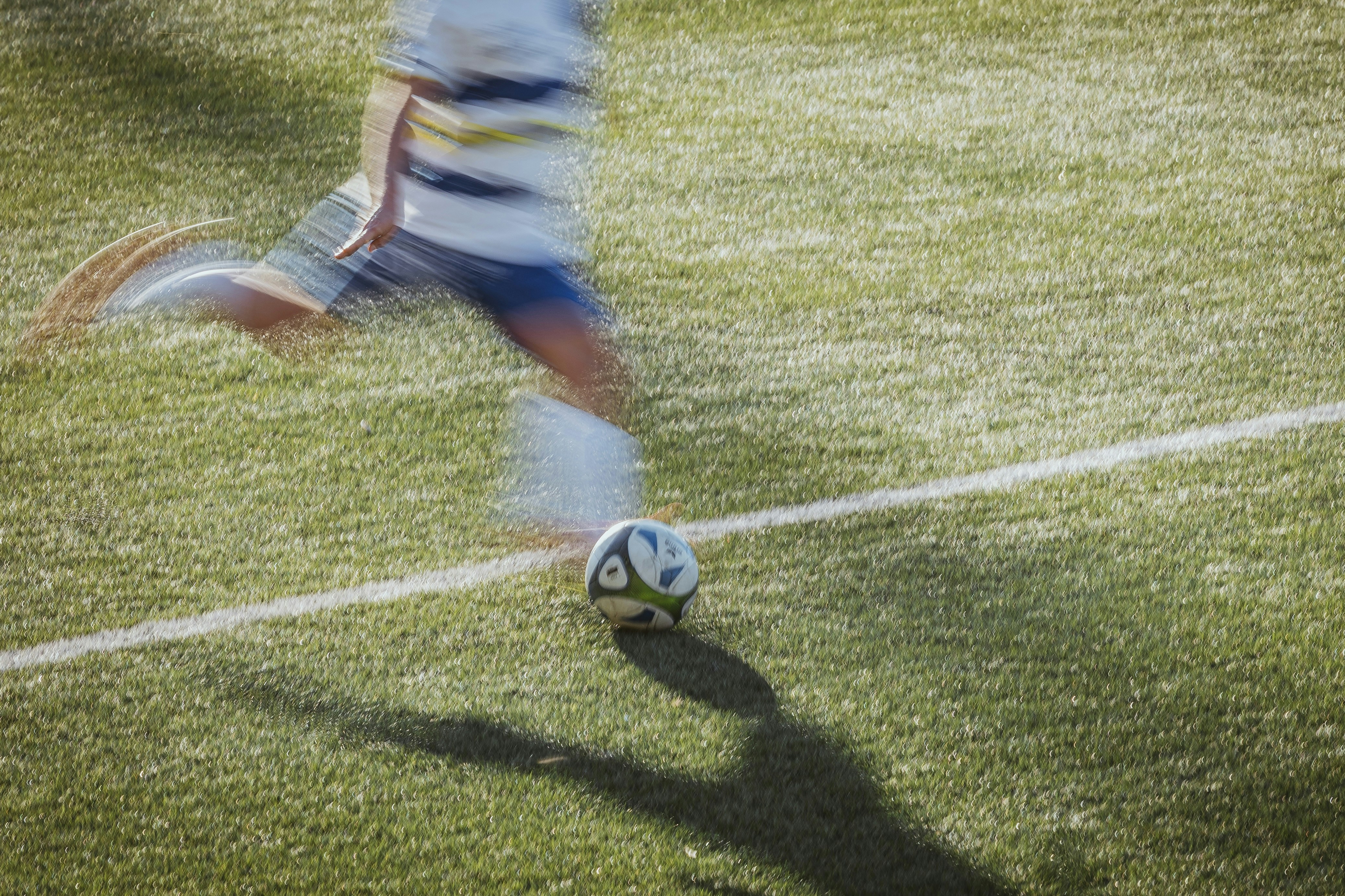 Person kicking soccer ball on field - Free Photo on Unsplash