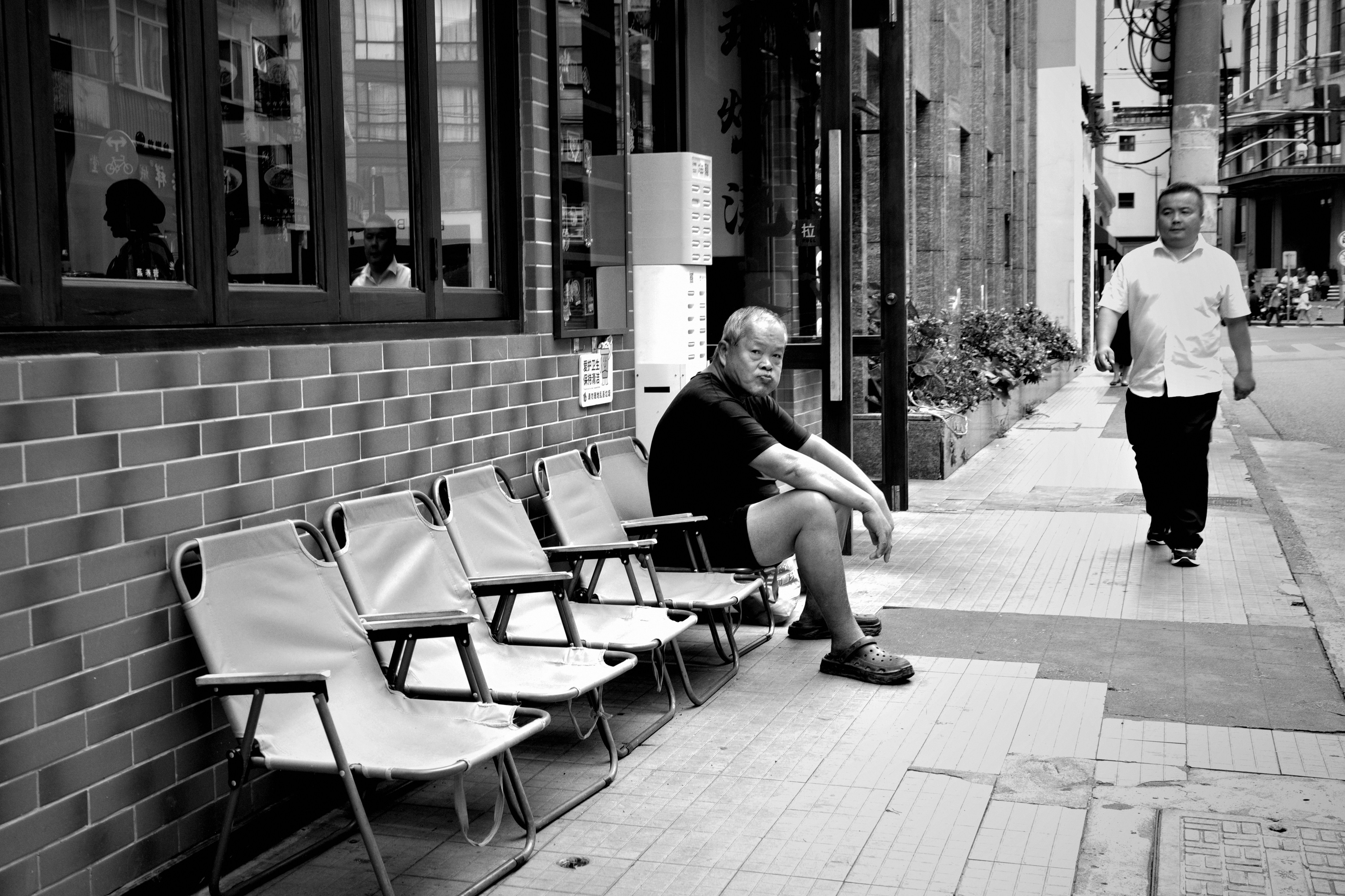 Man sitting on sidewalk folding chair - Free Photo on Unsplash