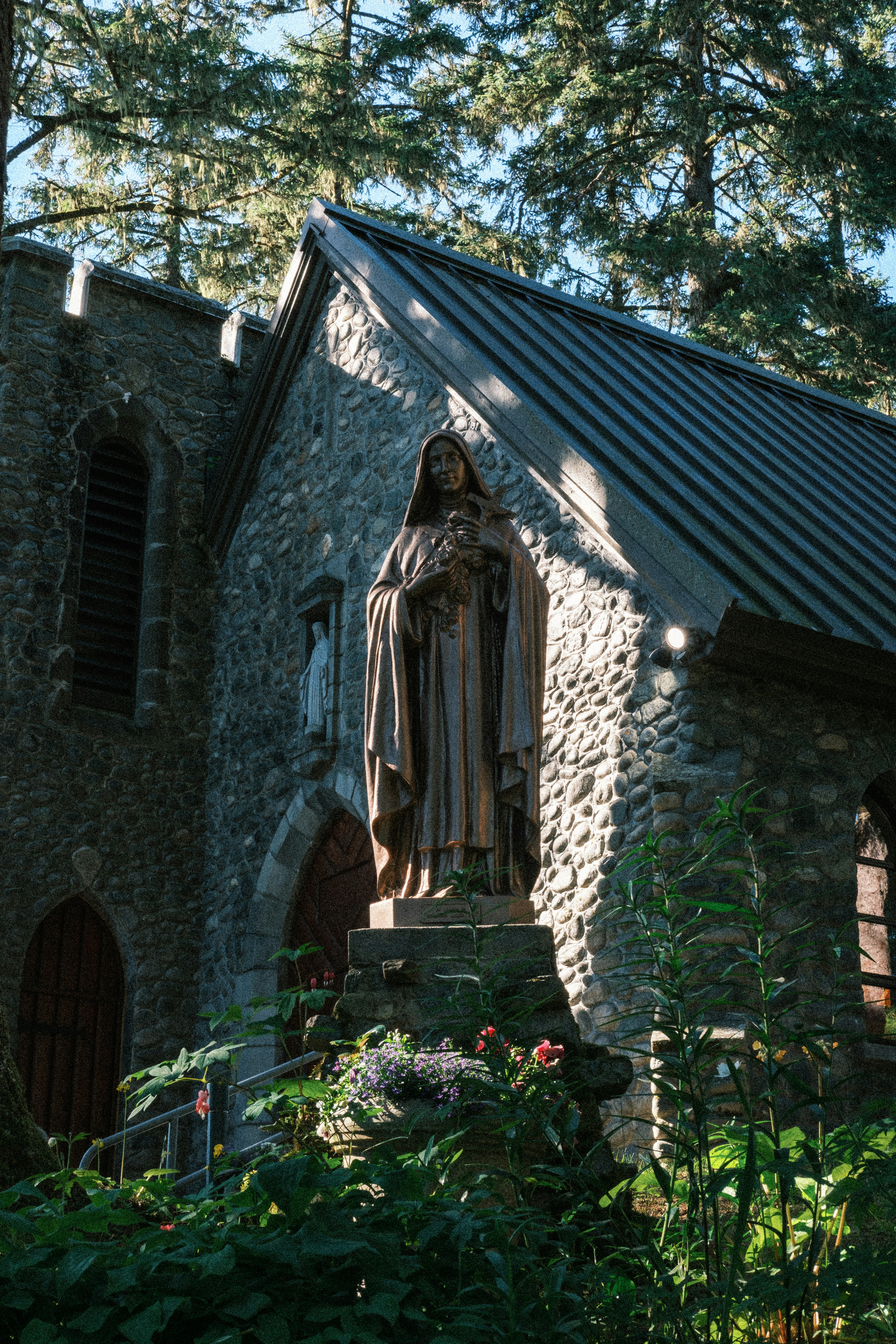 Bronze statue before stone chapel - Free Photo on Unsplash