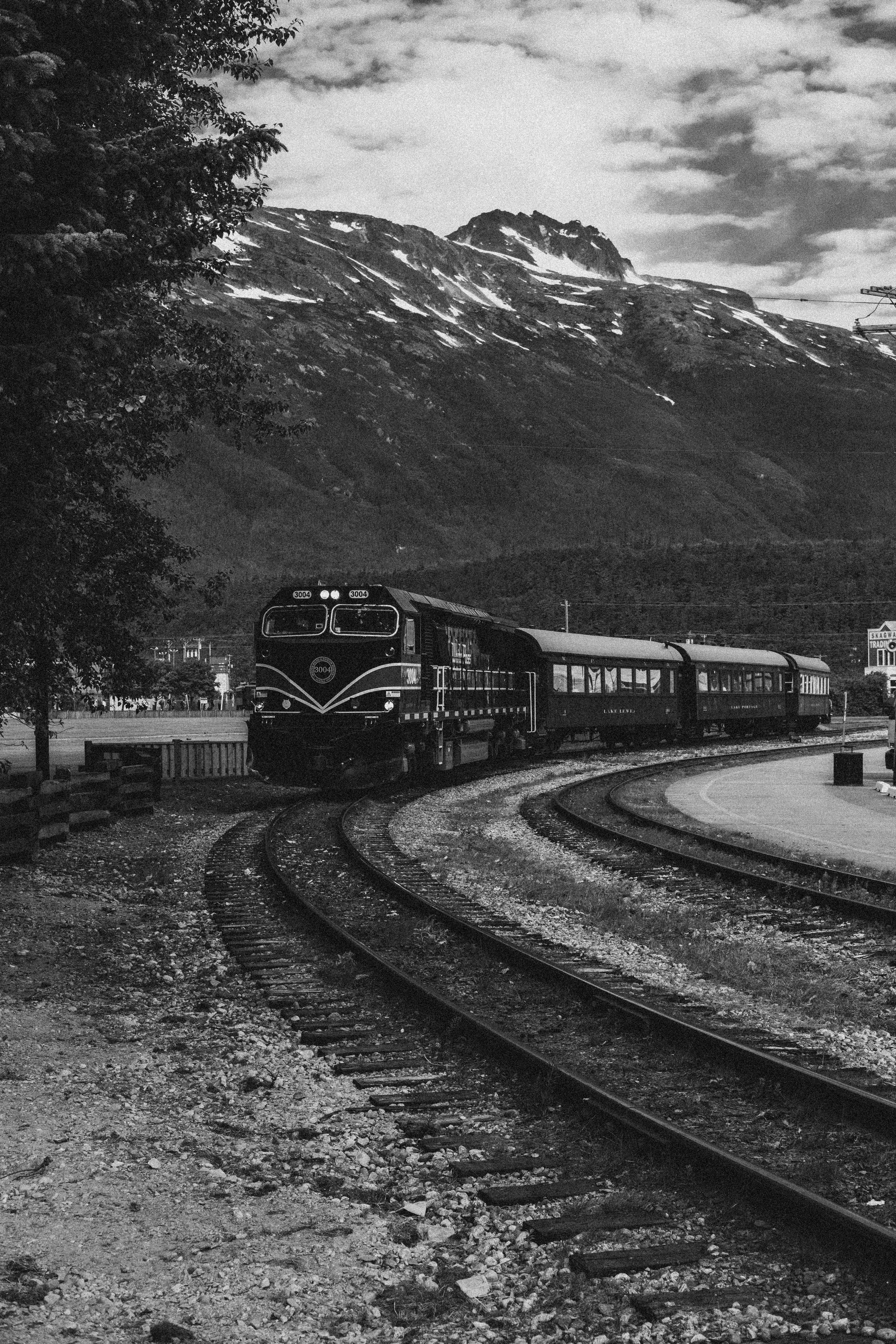 Train on curved tracks near mountain - Free Photo on Unsplash
