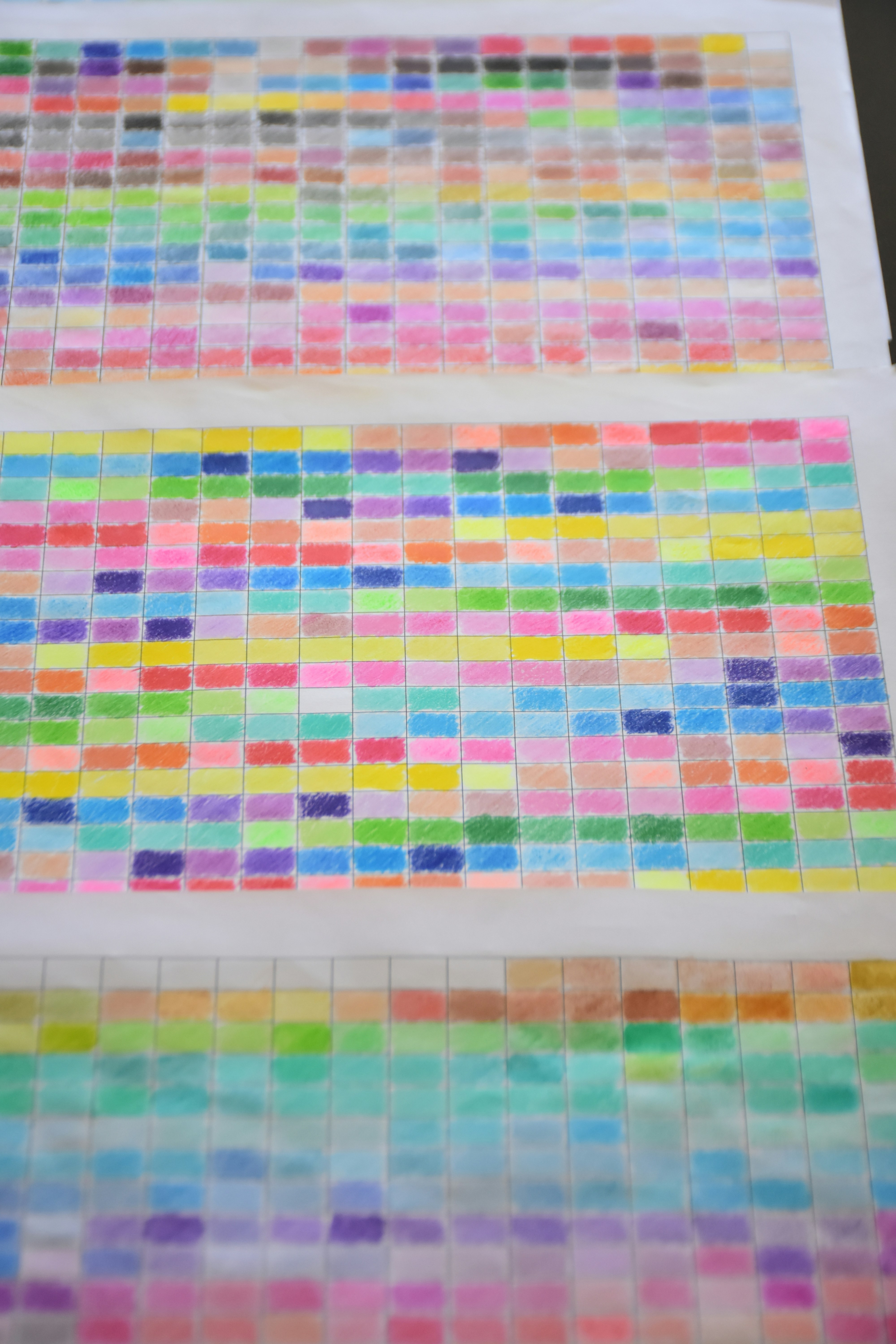 A sketch of a grid filled with many different colored pencil swatches on white paper