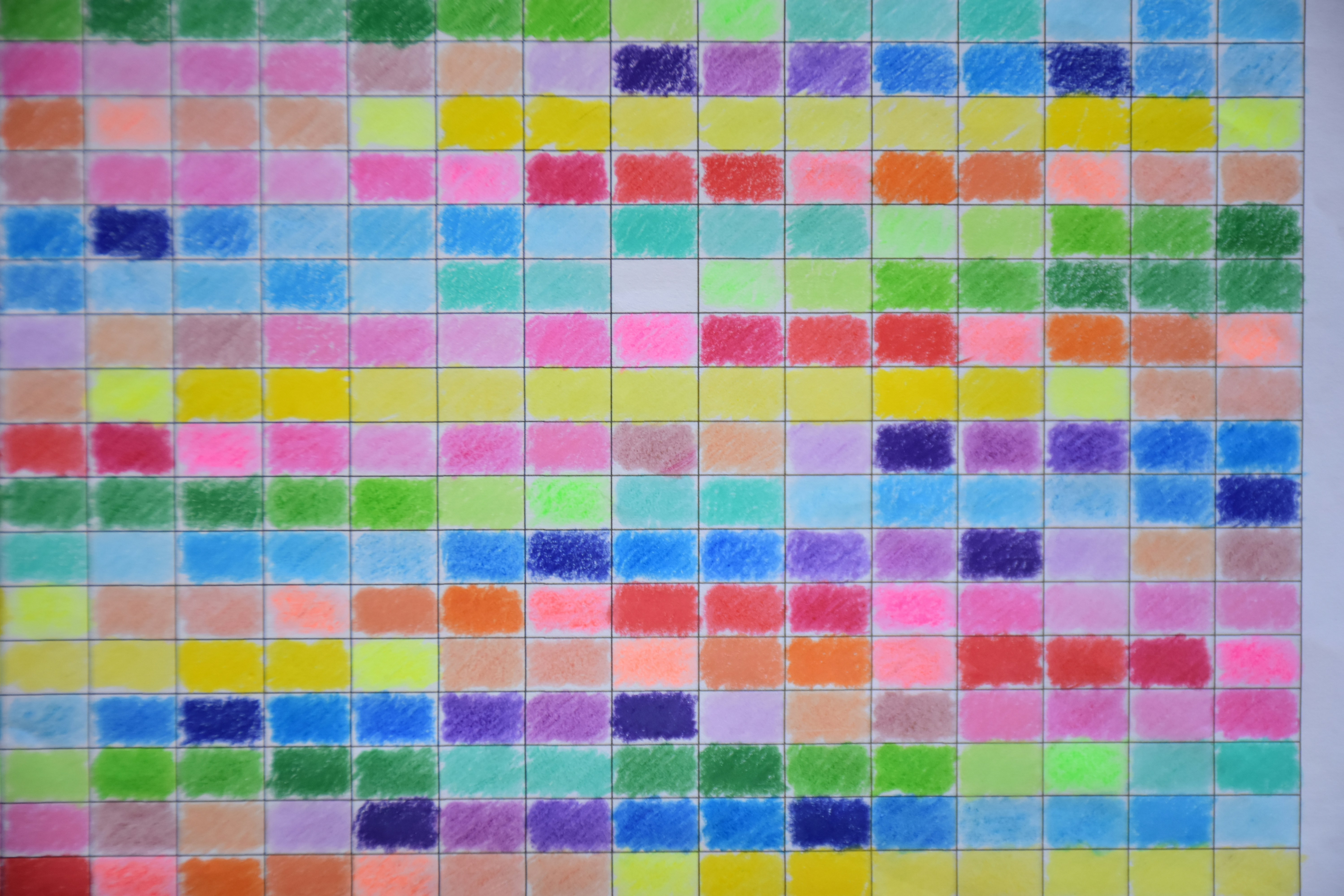 A grid of hand-drawn colored squares filled with various crayon shades on white paper