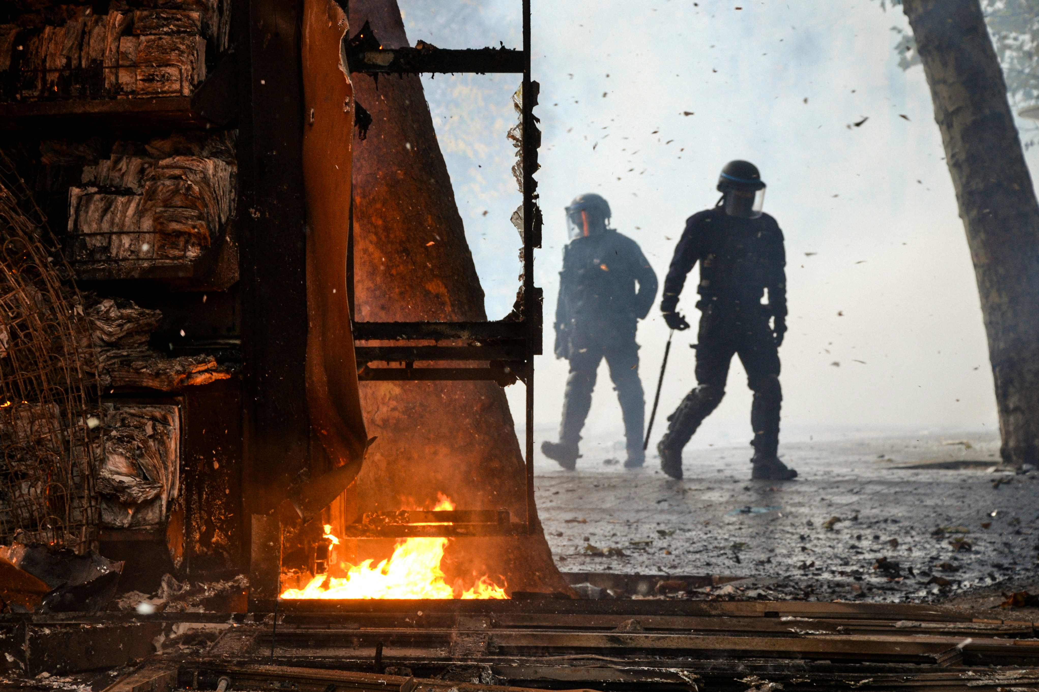 Police officers walking past burning structure - Free Photo on Unsplash