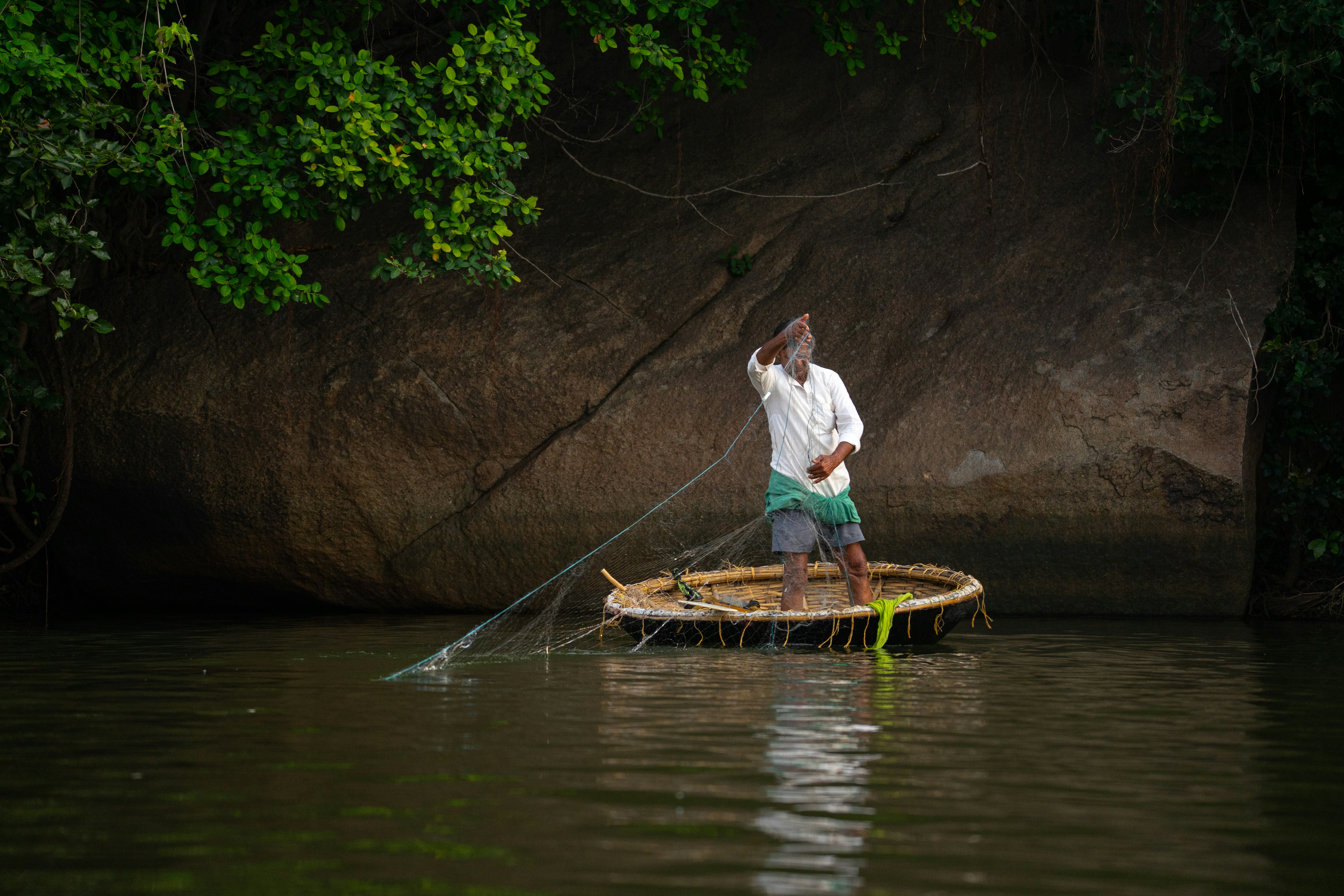 Fisherman casting net from coracle boat - Free Photo on Unsplash