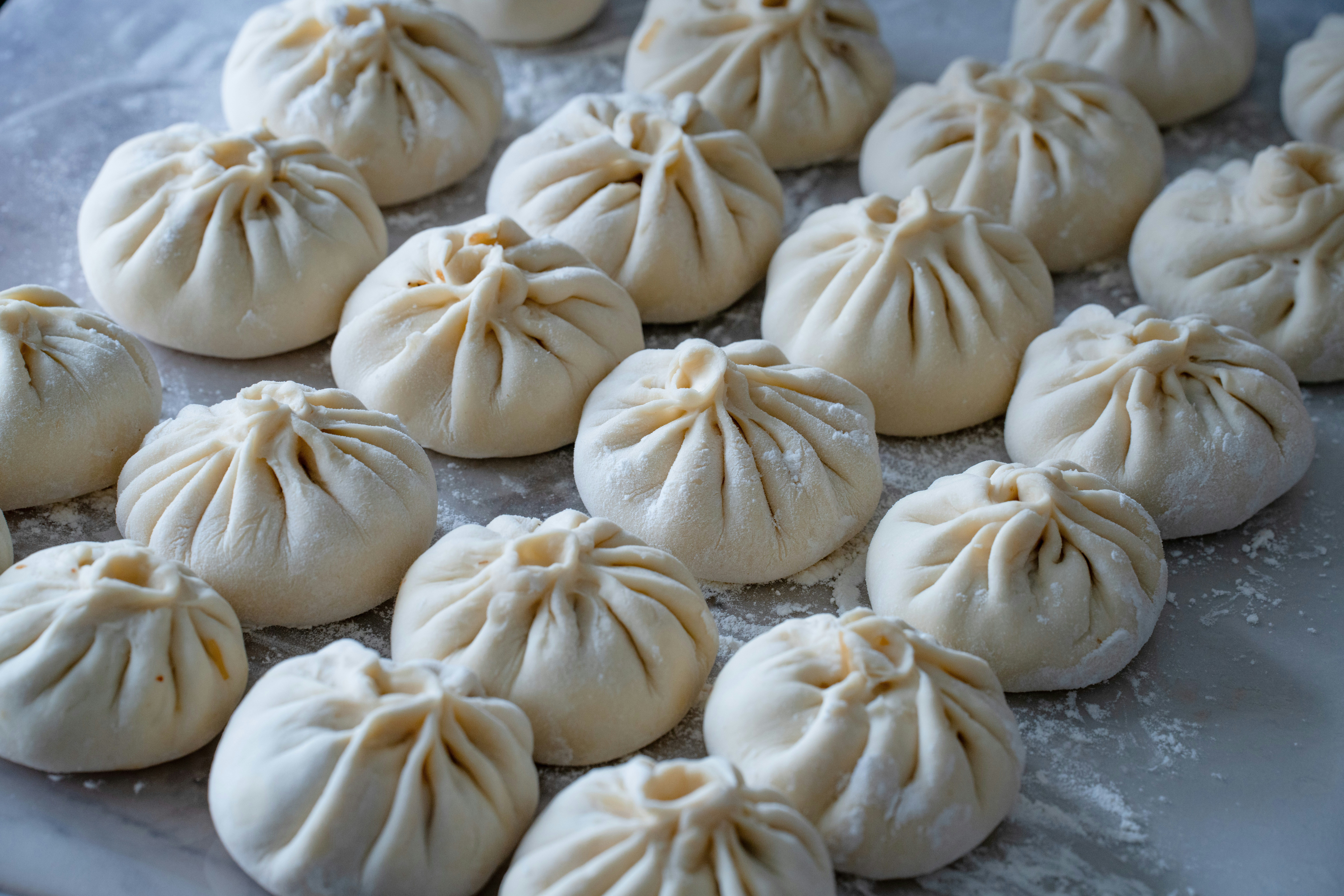 Raw pleated dumplings on floured surface - Free Photo on Unsplash