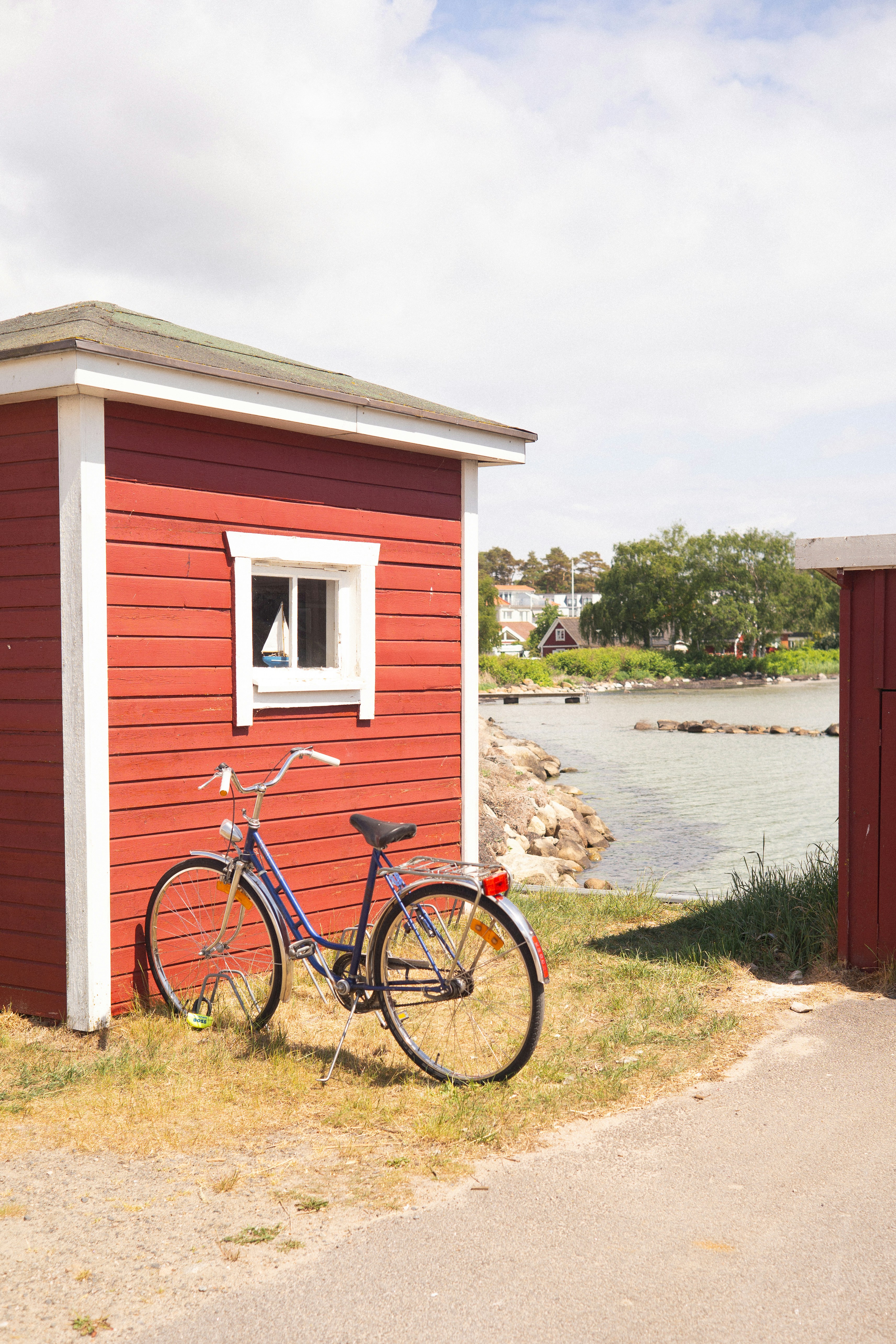 Blue bicycle beside red wooden shed - Free Photo on Unsplash