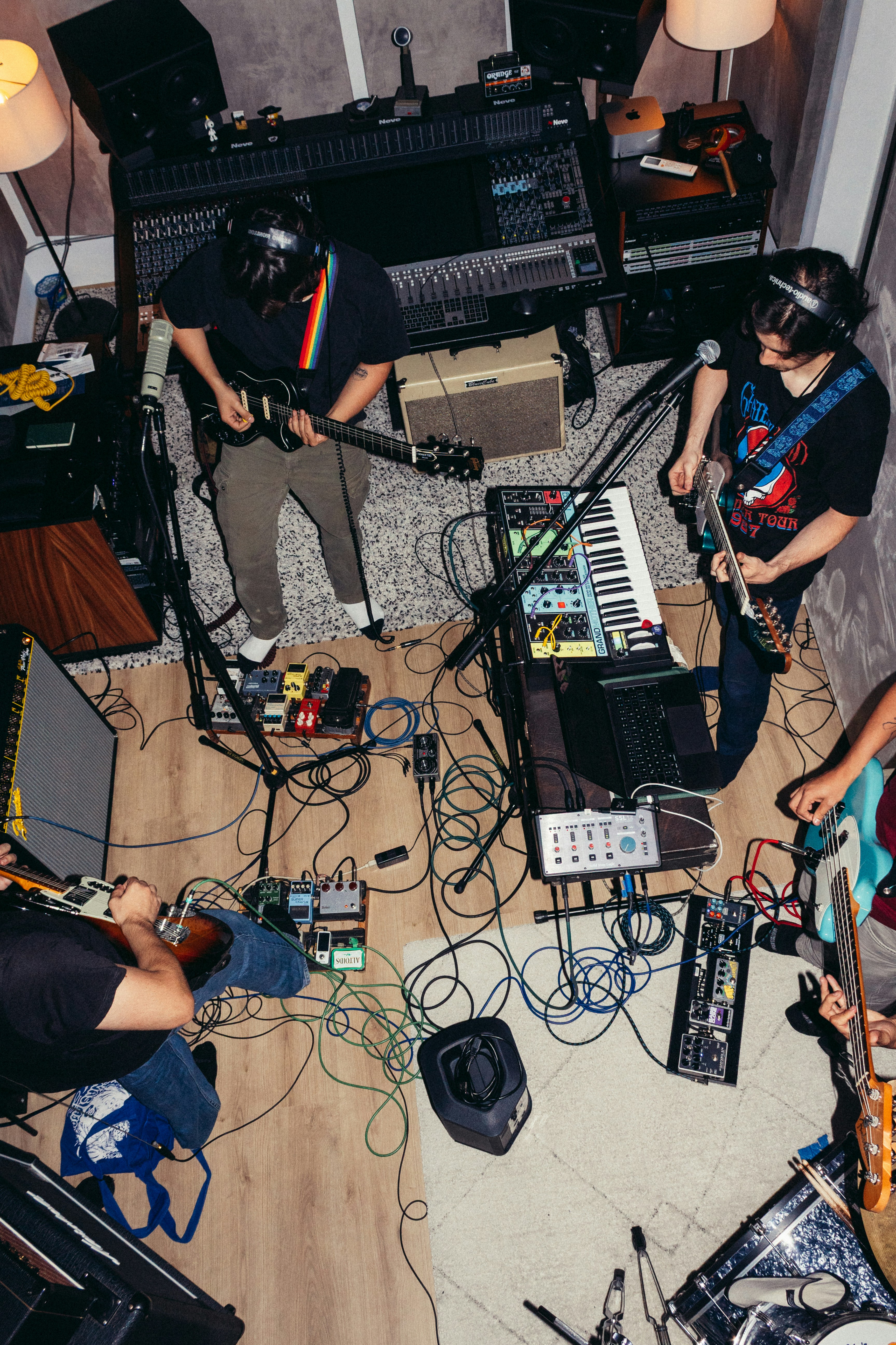 A band playing instruments in a recording studio with cables scattered across the floor - 相关推荐