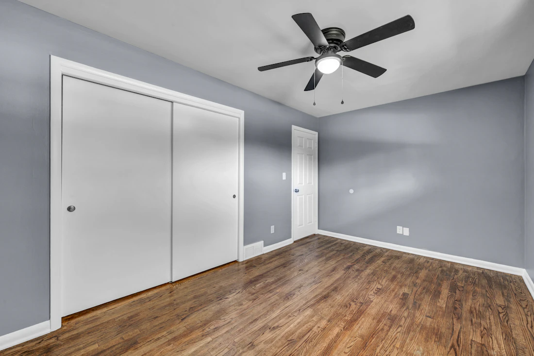 Empty bedroom with gray painted walls and white closet doors