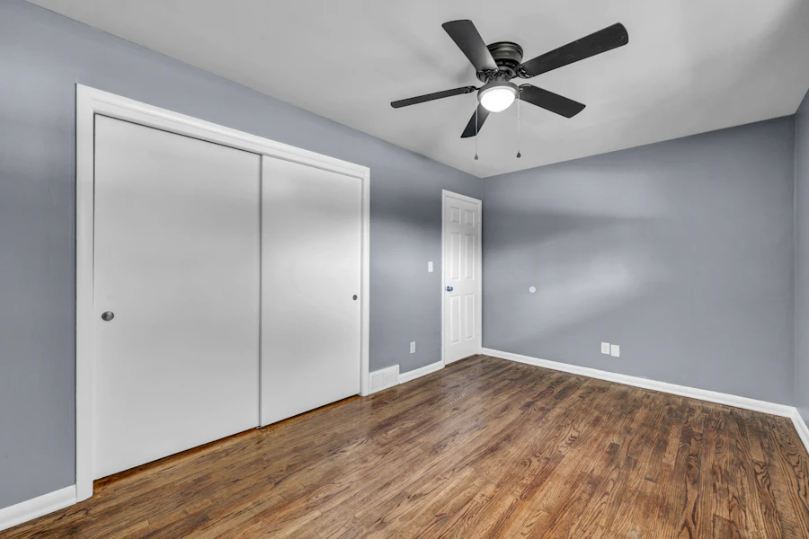 Empty bedroom with gray painted walls and white closet doors