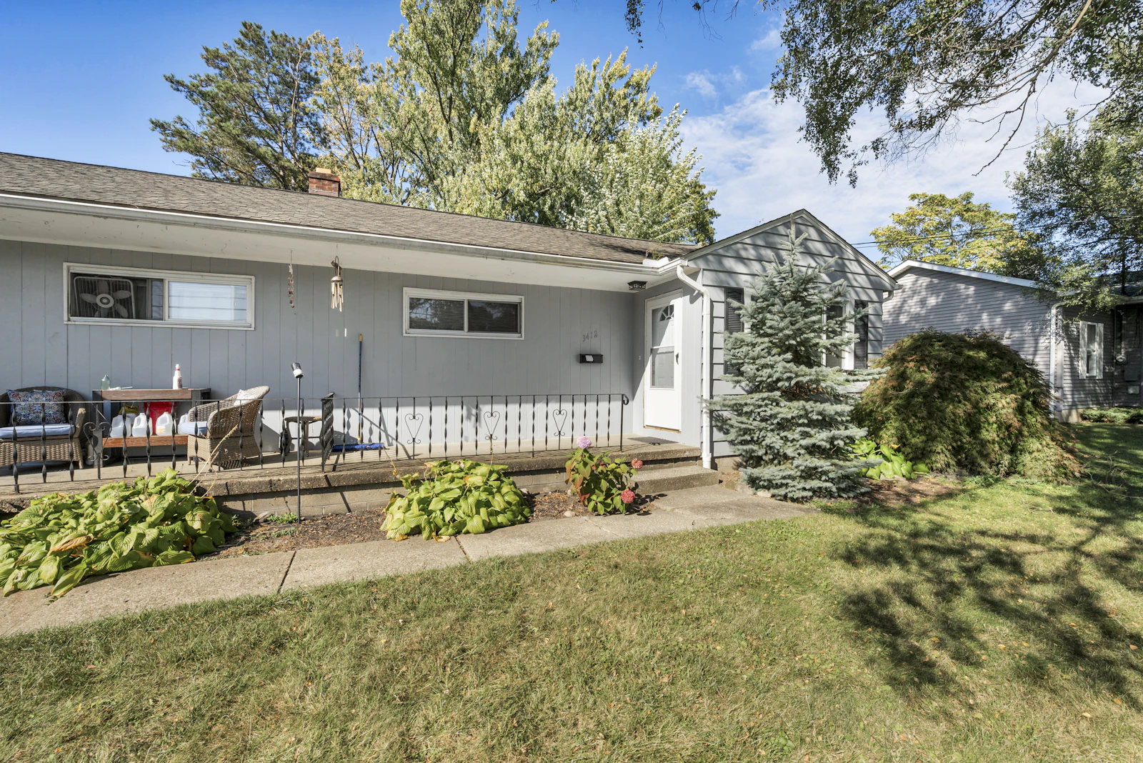 Single-story home with a front porch and a small evergreen tree