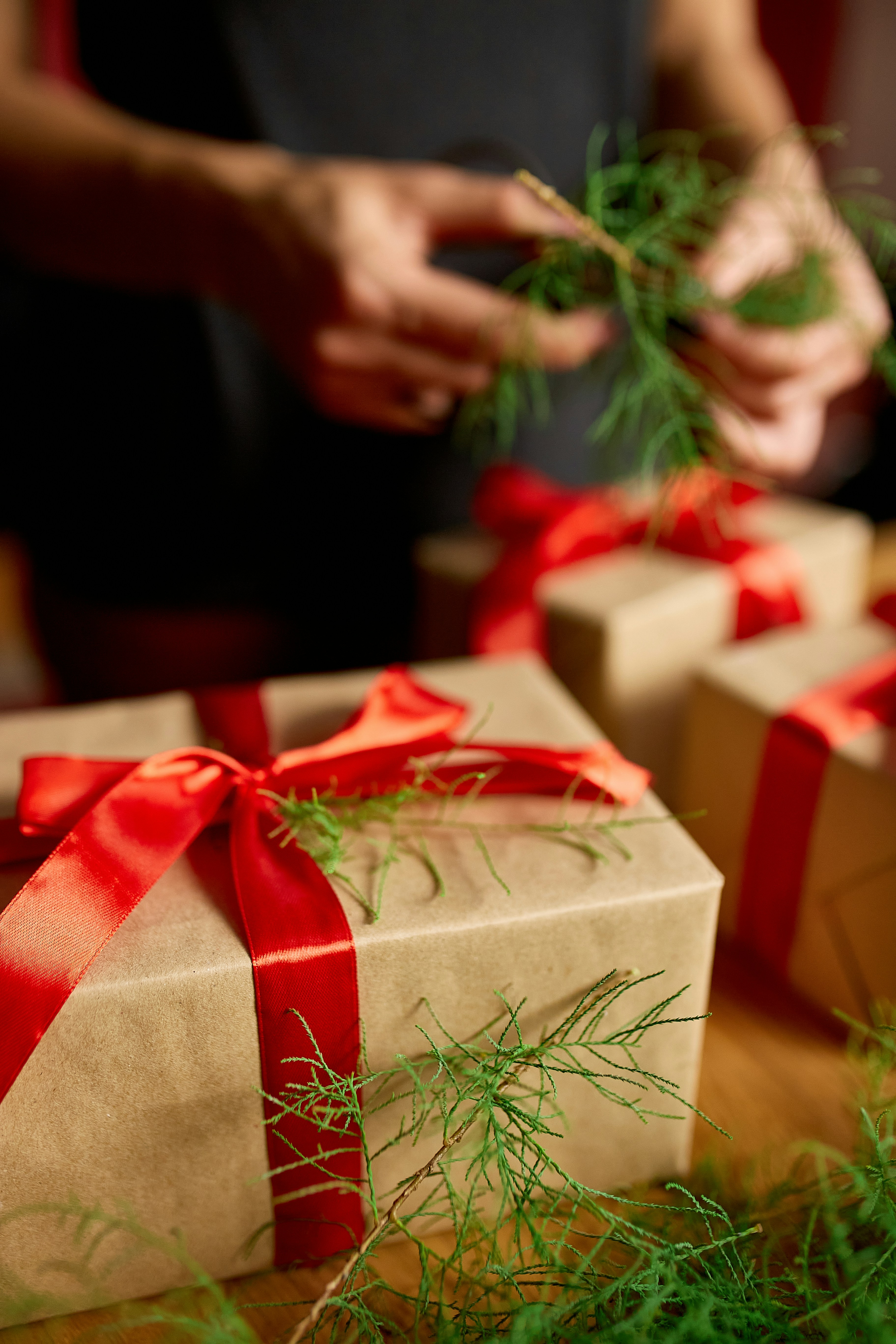 Person wrapping gifts with red ribbons - Free Photo on Unsplash