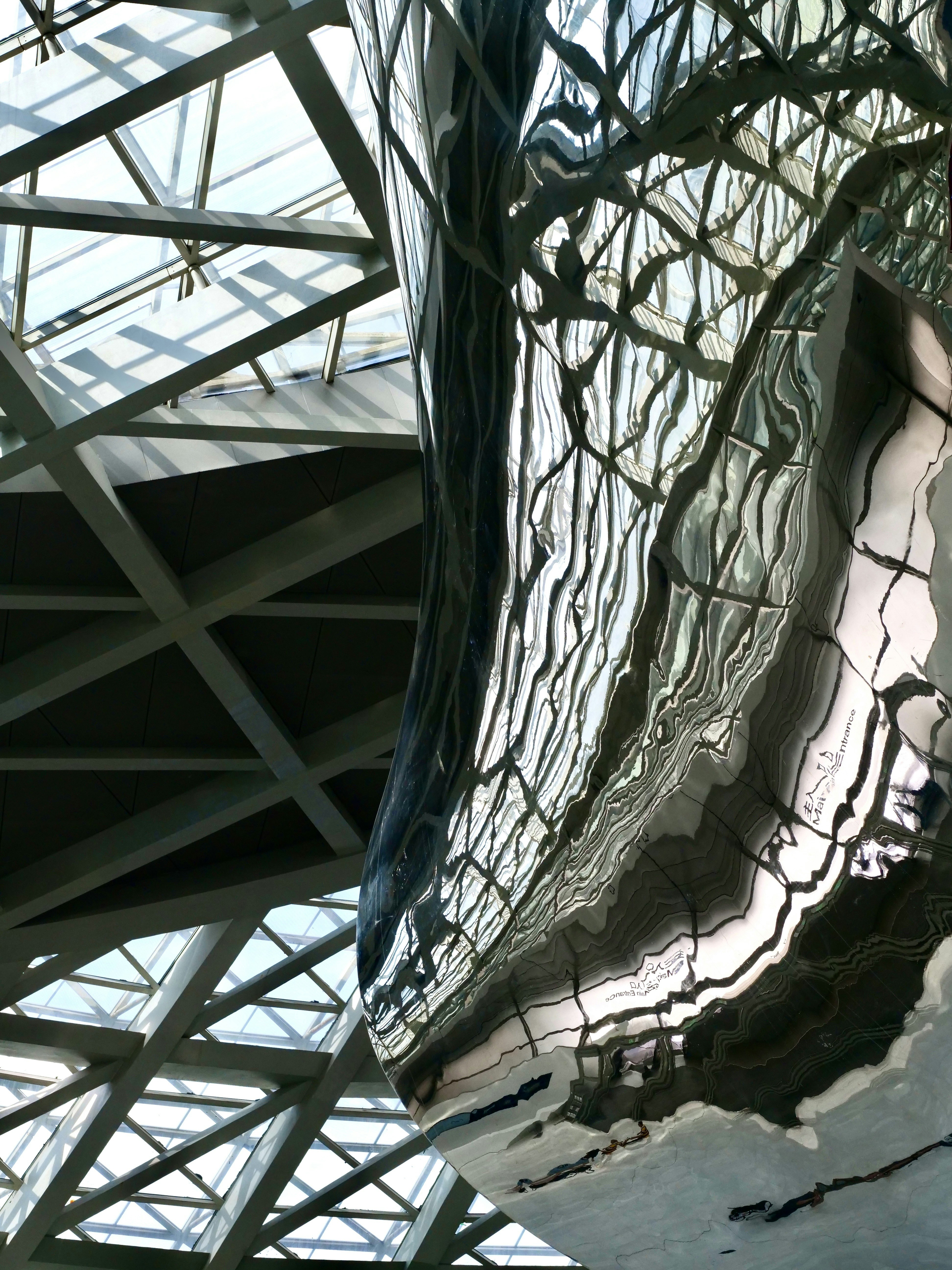 Curved metal sculpture with ceiling reflection - Free Photo on Unsplash