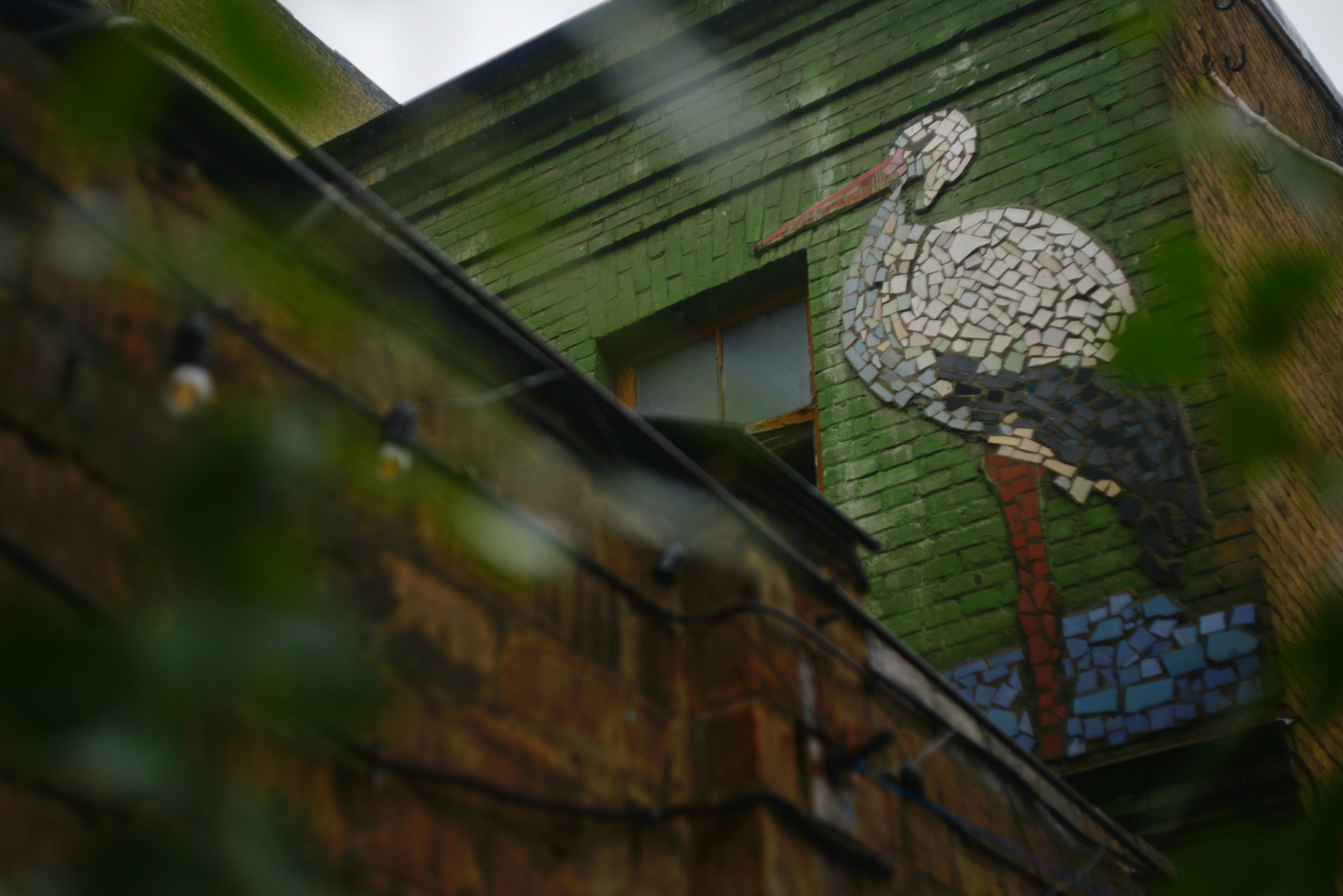 Stork mosaic on green brick wall - Free Photo on Unsplash