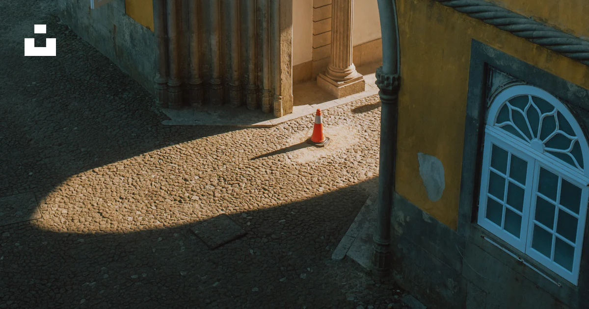 Cone Shadow Perspective Traffic cone in yellow building archway - Free Photo on Unsplash