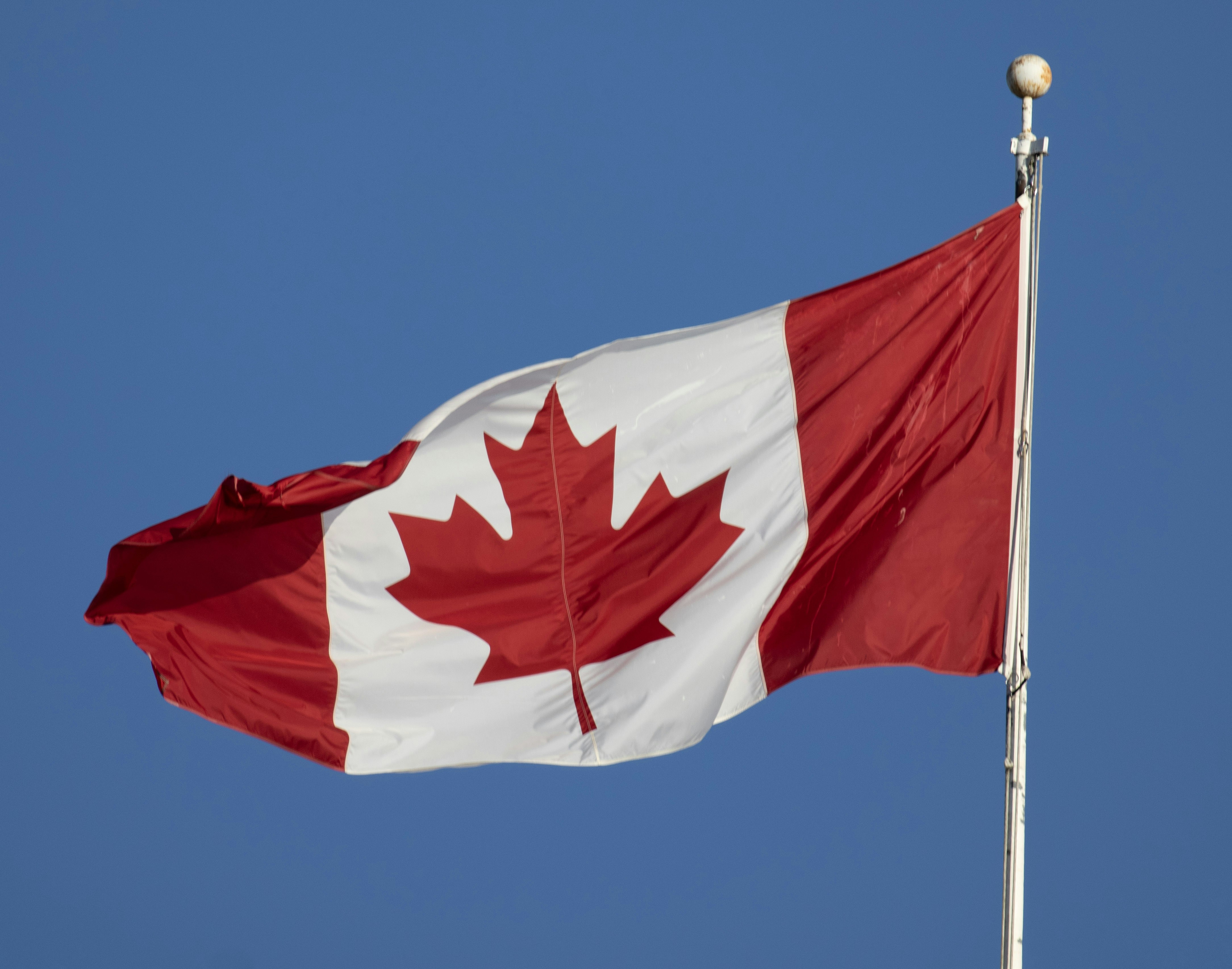 Canadian flag waving against blue sky - Free Photo on Unsplash