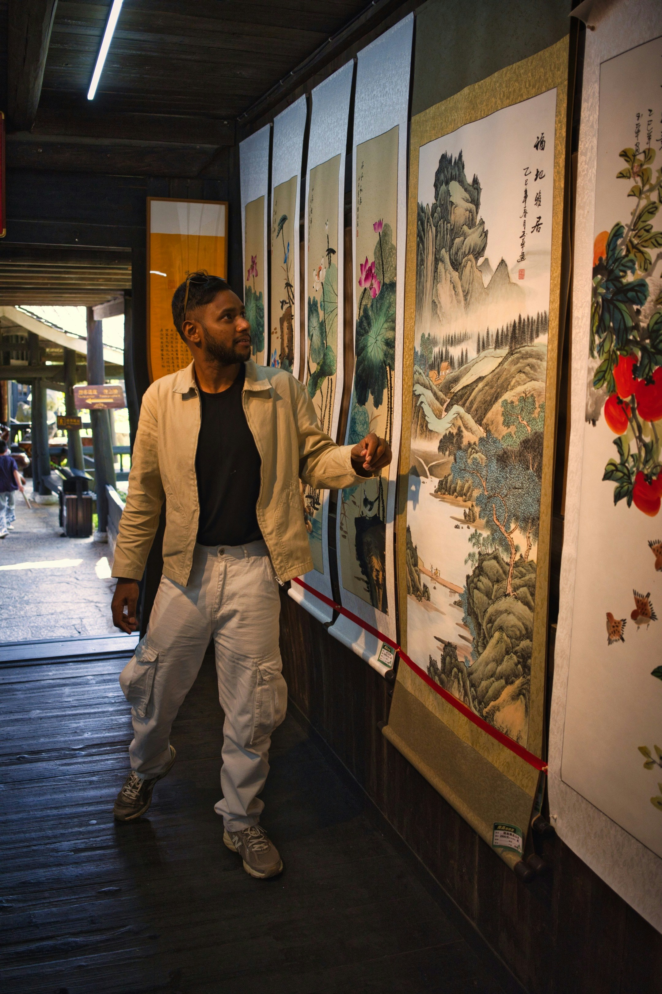 Man looking at traditional scroll paintings - Free Photo on Unsplash