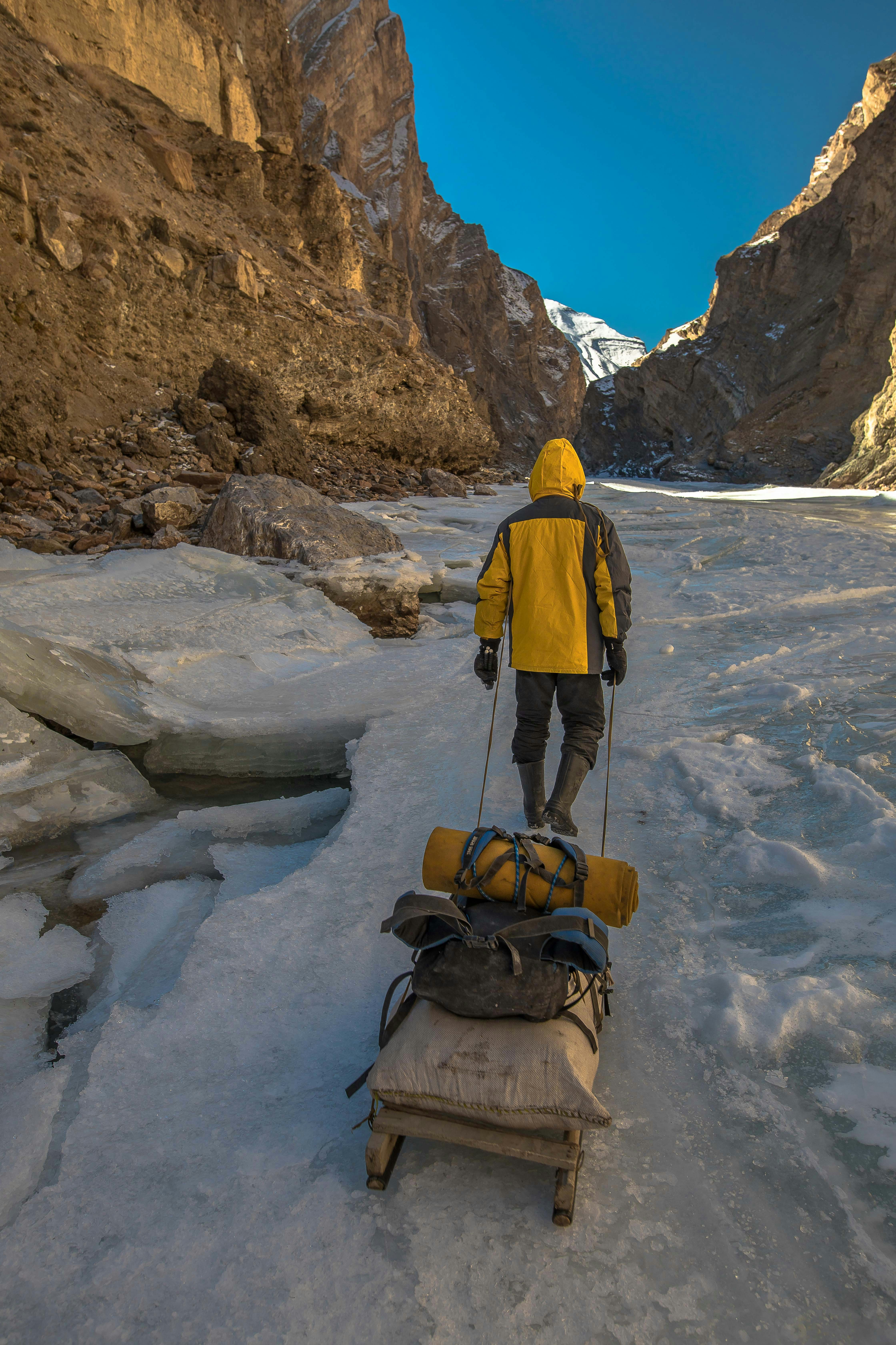 Person pulling sled on frozen river - Free Photo on Unsplash