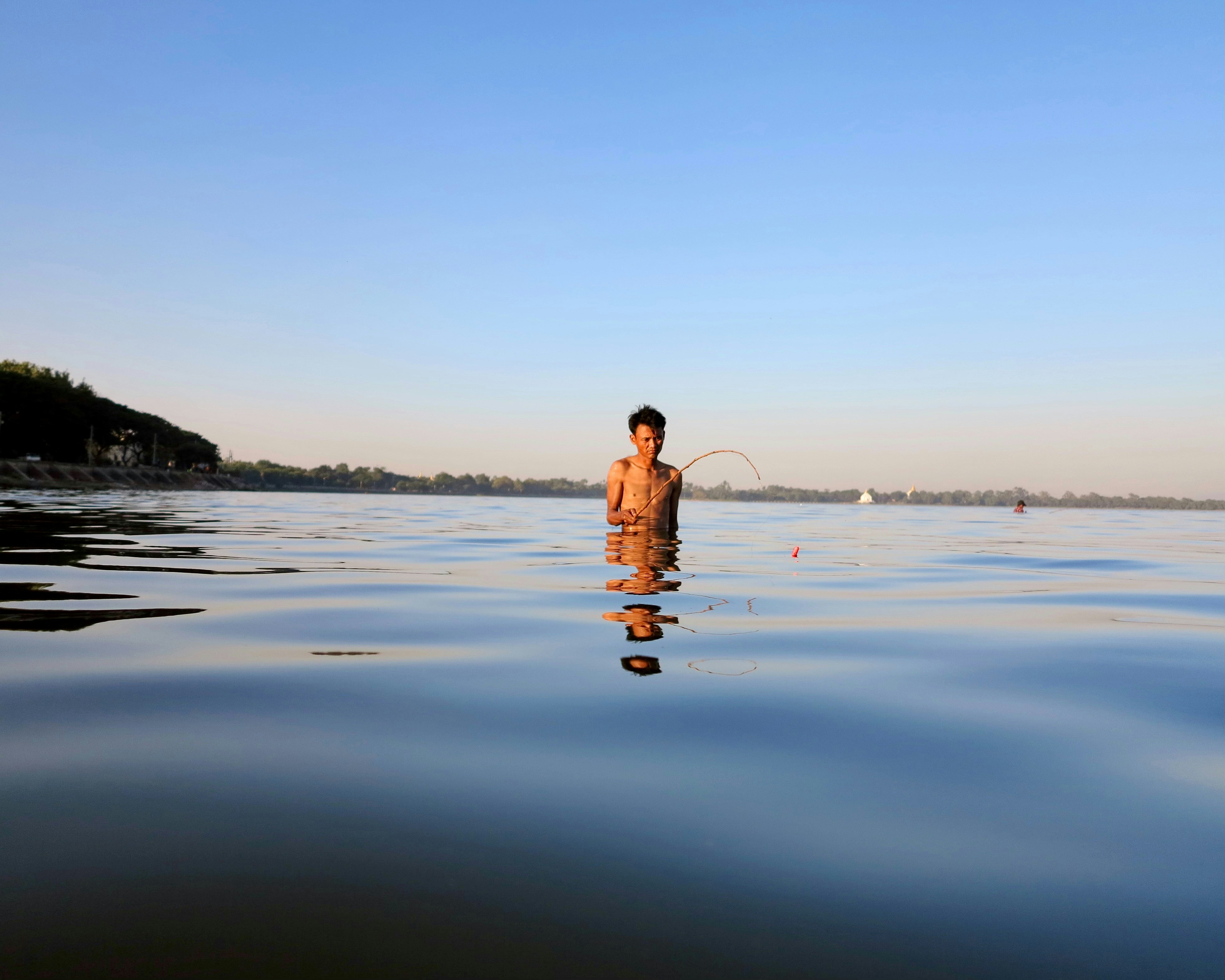 Man fishing in calm blue water - Free Photo on Unsplash