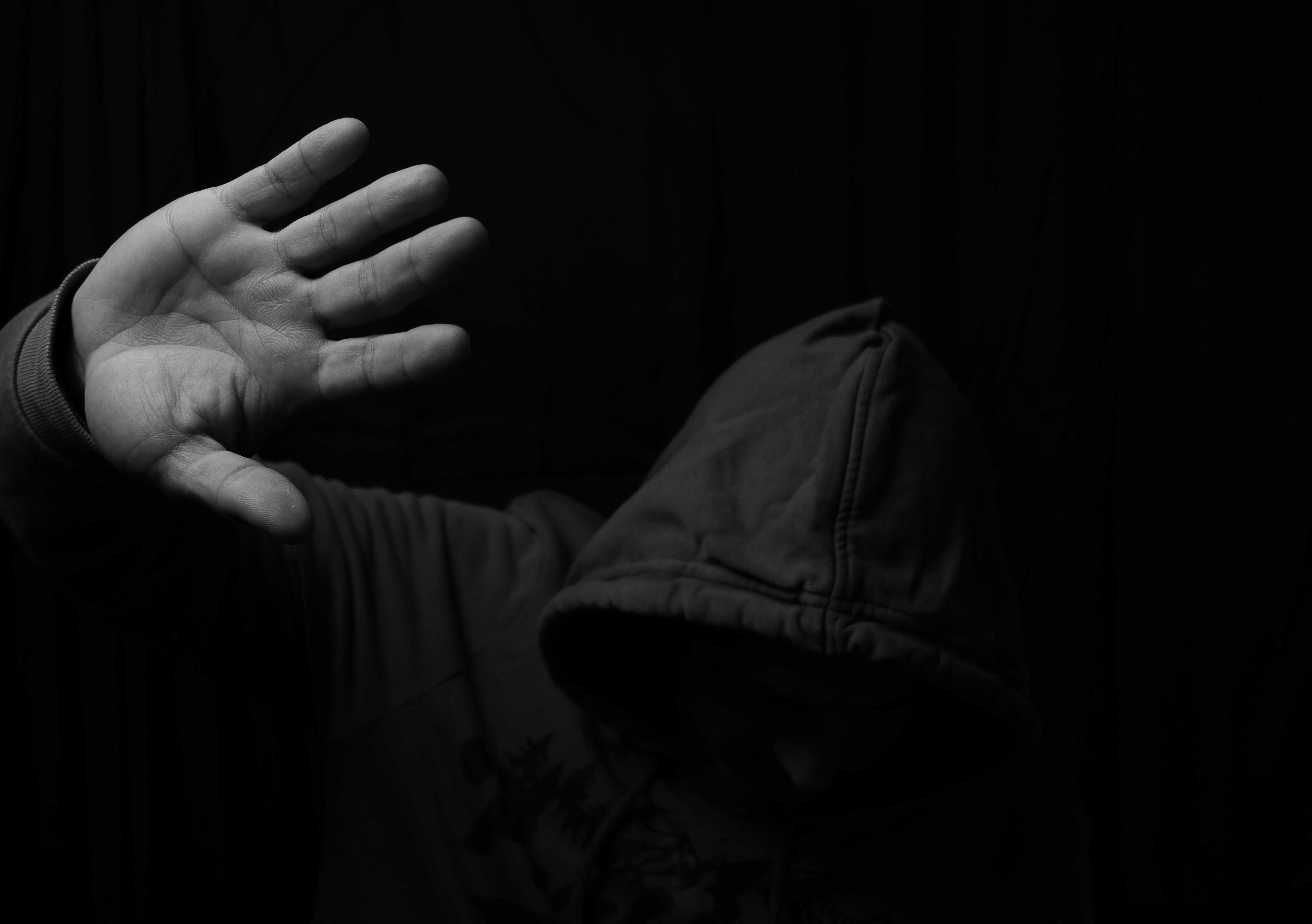 Person in hoodie holding up hand - Free Photo on Unsplash