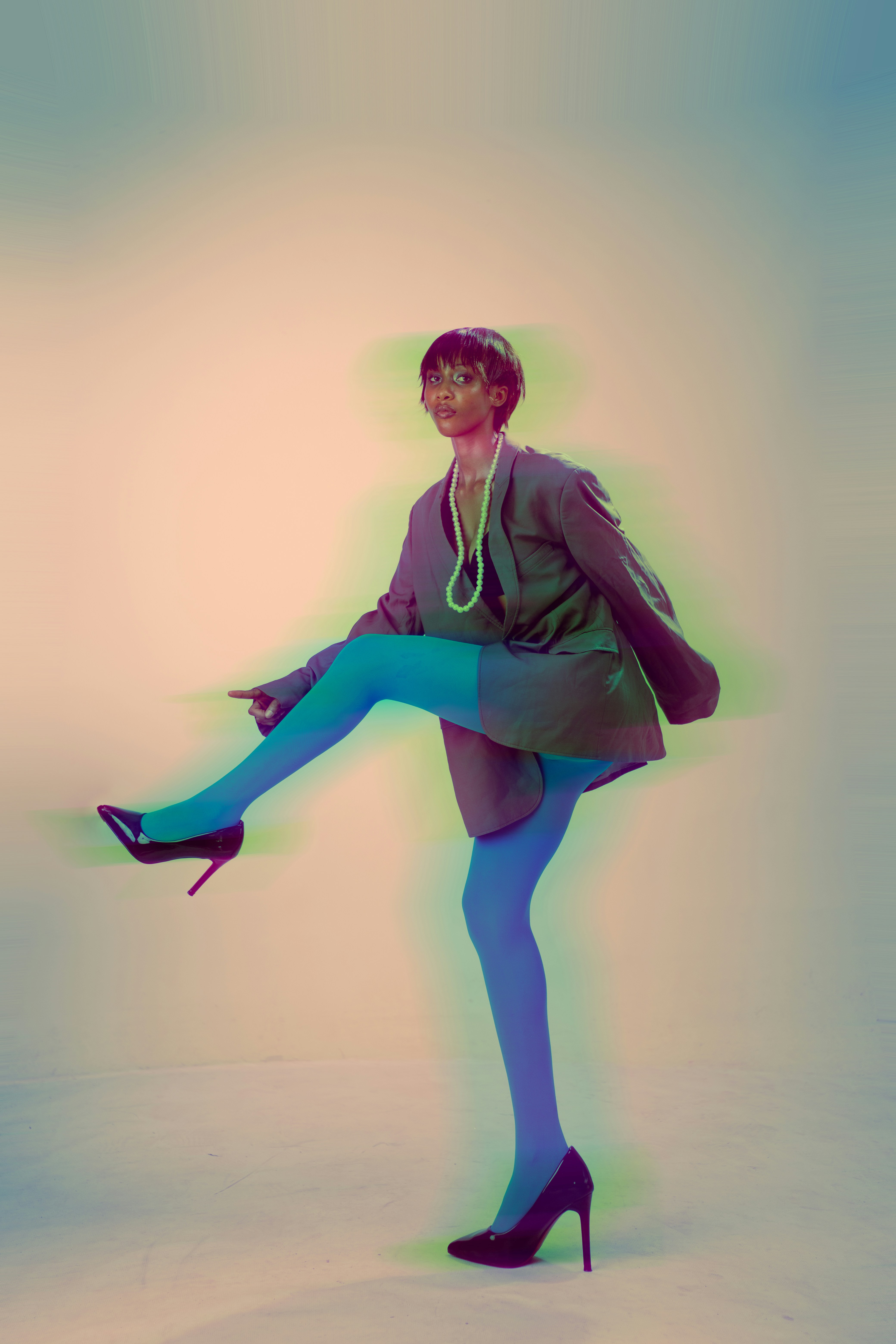 A woman in a blazer and blue tights lifting one leg with a motion blur effect - 相关推荐