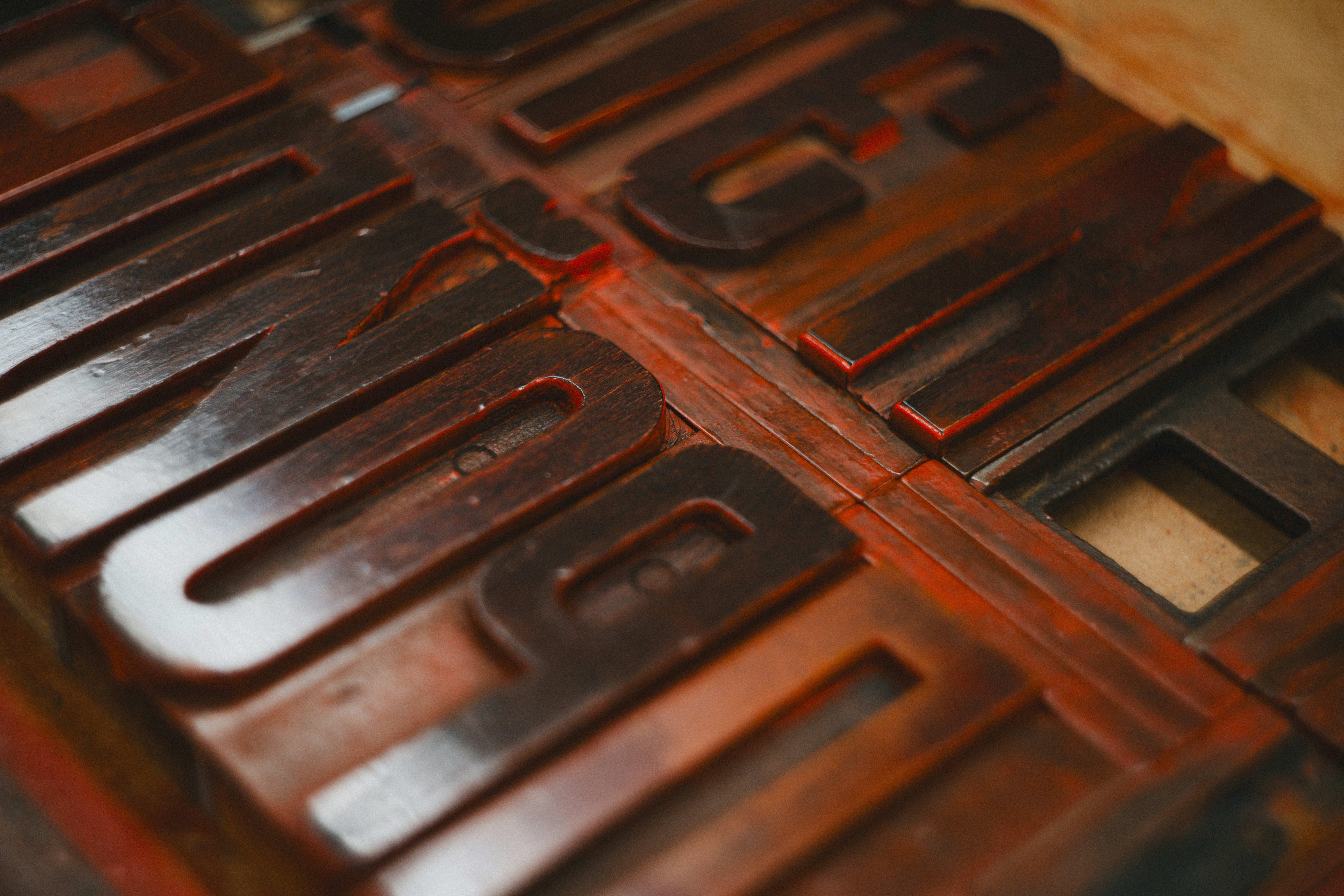 Close-up of dark wooden letterpress type blocks arranged on a flat surface