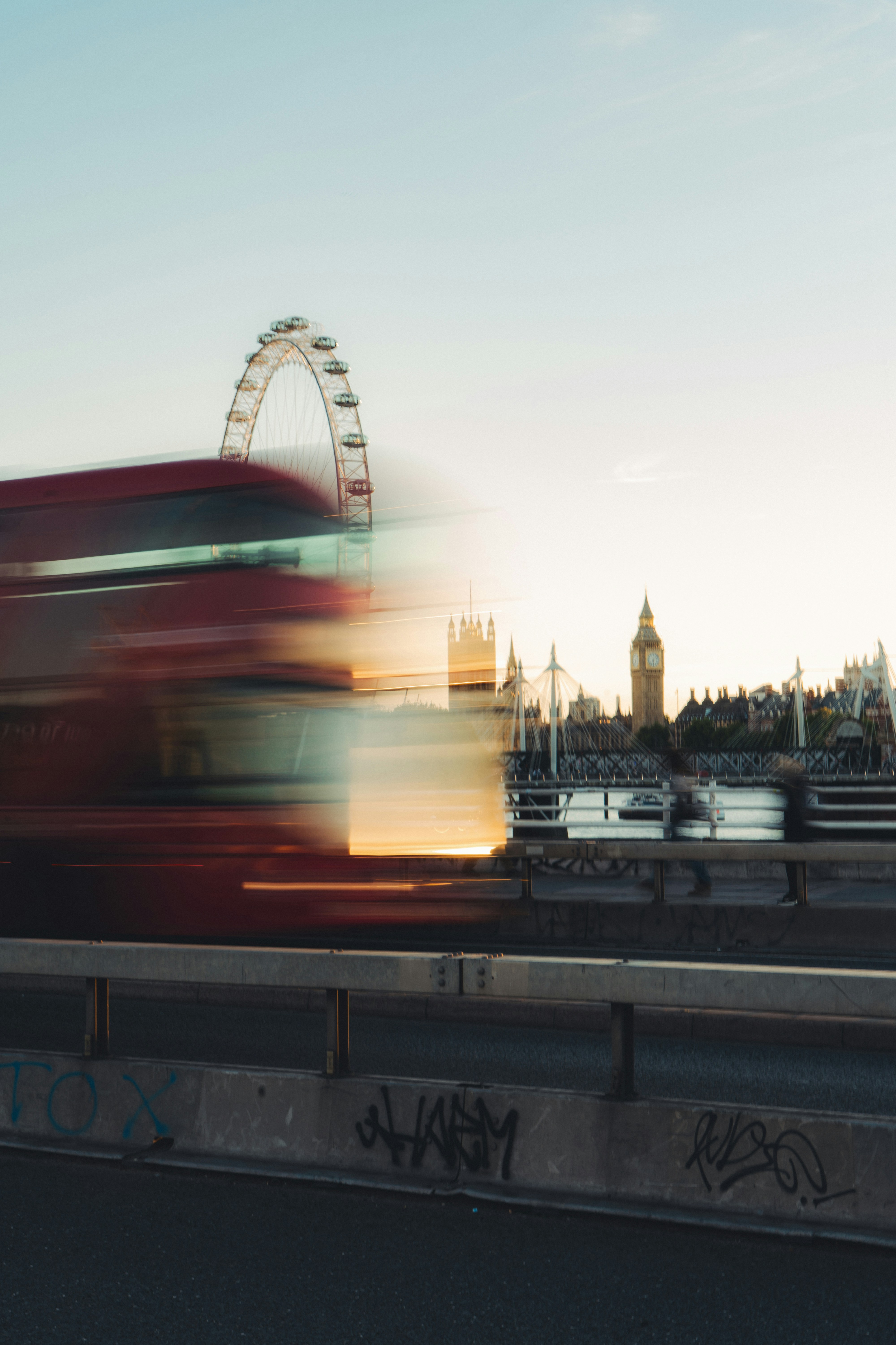 A motion-blurred red bus crossing Westminster Bridge with the London Eye and Big Ben in the background - 相关推荐