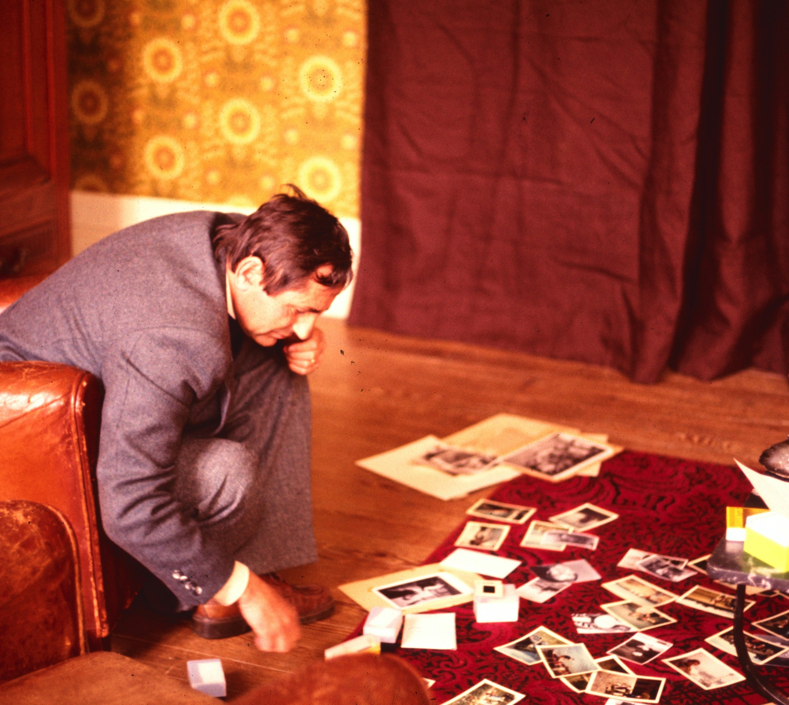 Man sorting photographs on wooden floor - Free Photo on Unsplash