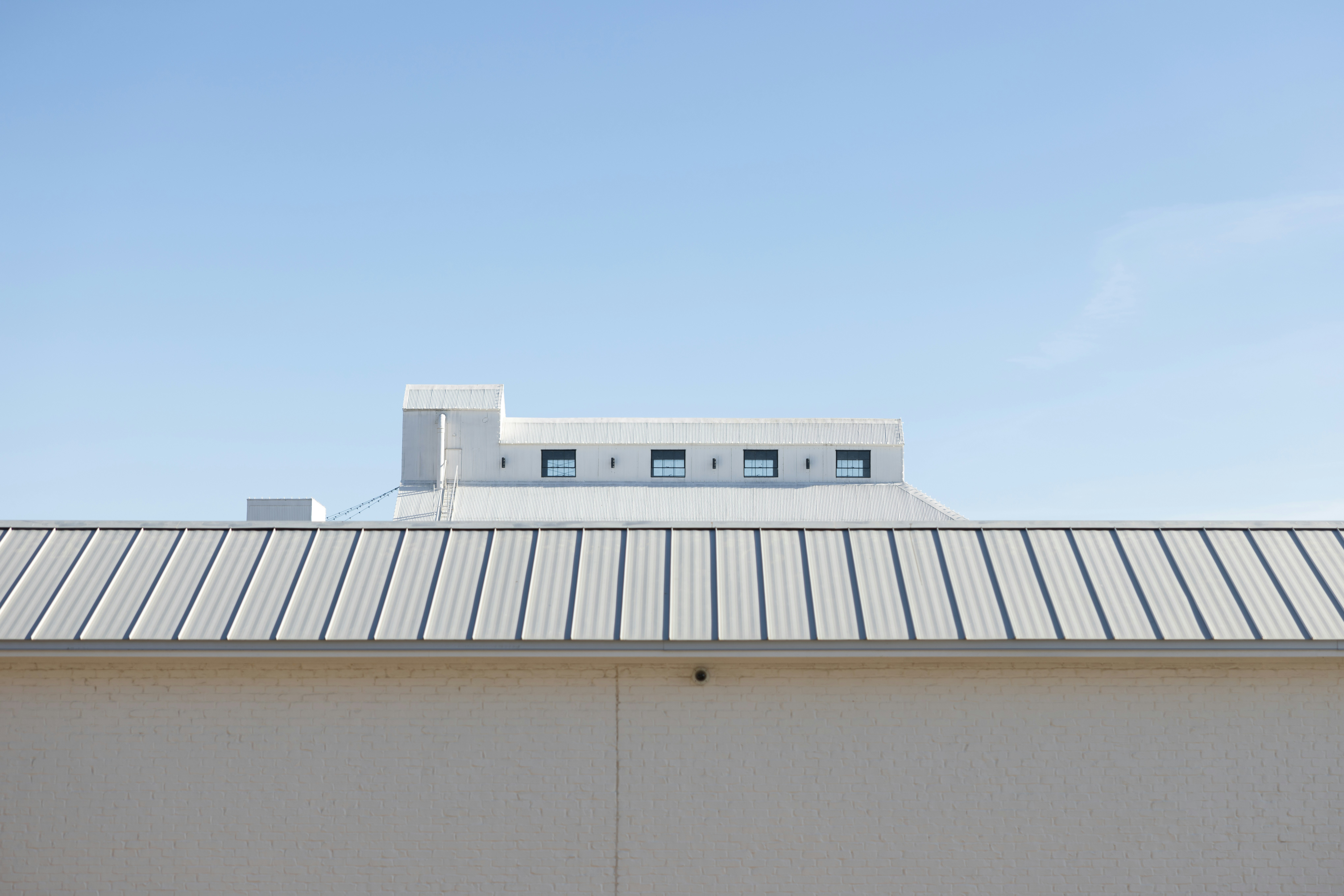 White industrial building with metal roof - Free Photo on Unsplash