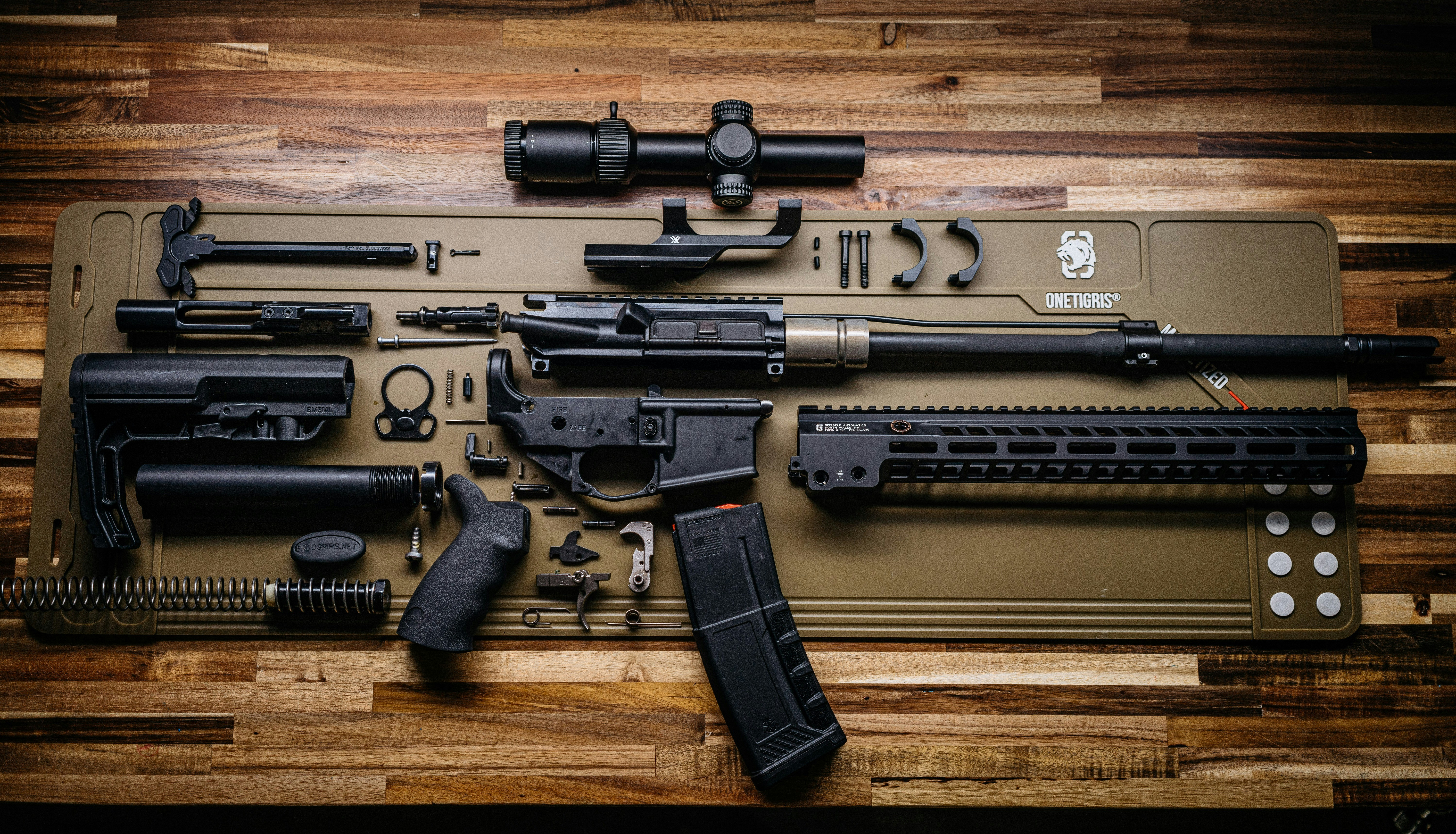 Disassembled rifle parts on cleaning mat - Free Photo on Unsplash