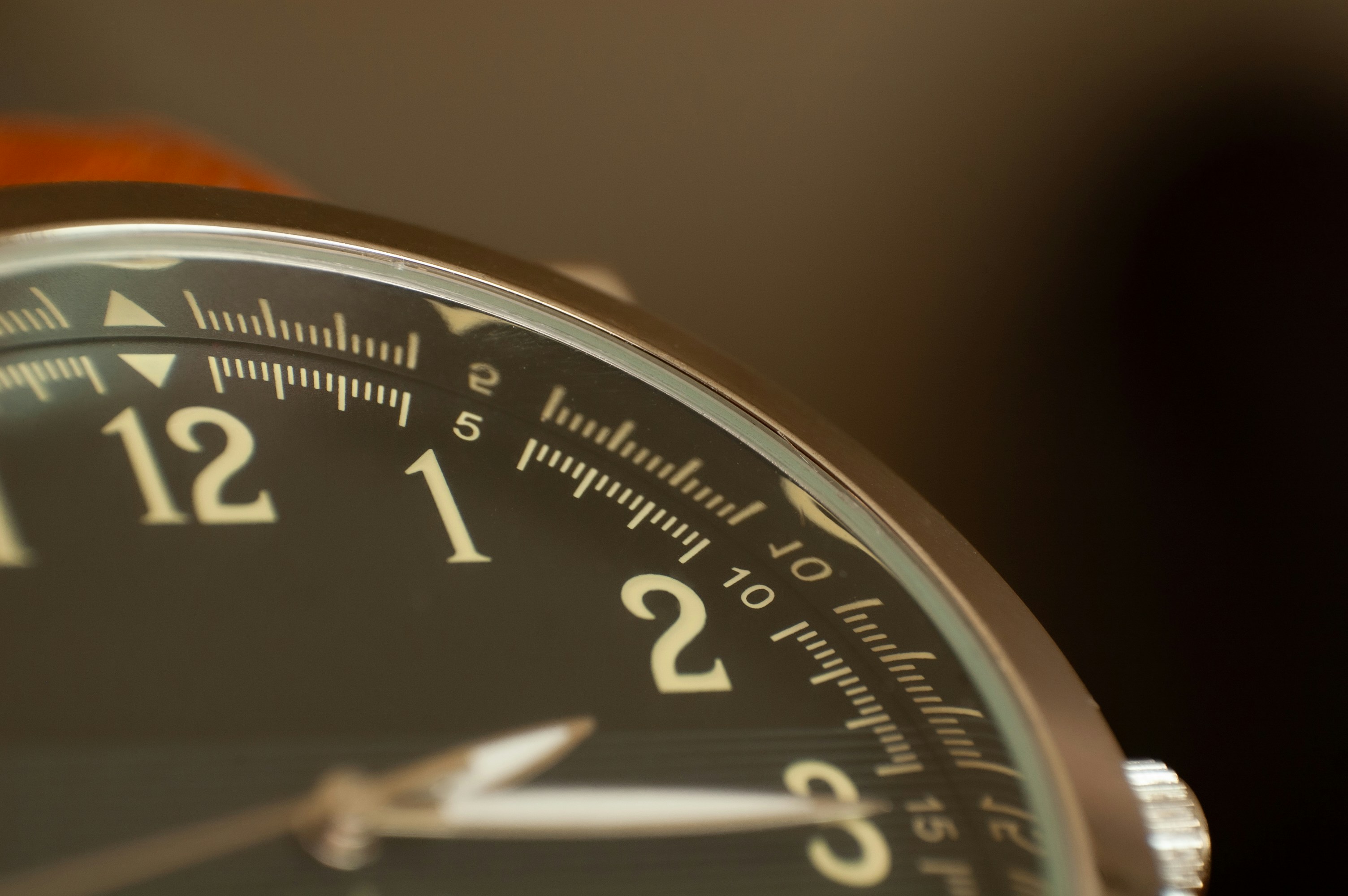 Macro view of a black watch face with white numerals and a silver bezel