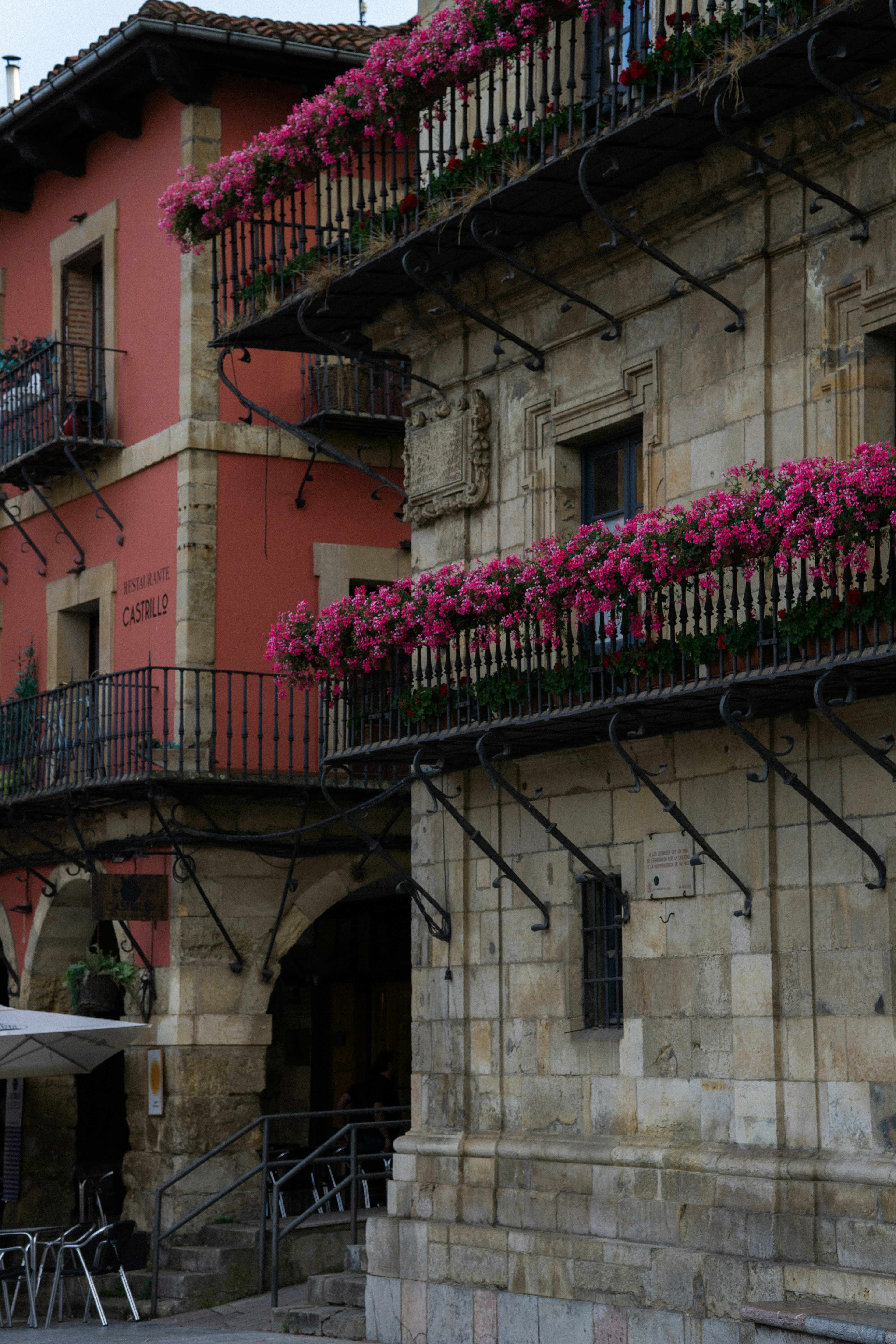 Pink geraniums on stone building balconies - Free Photo on Unsplash