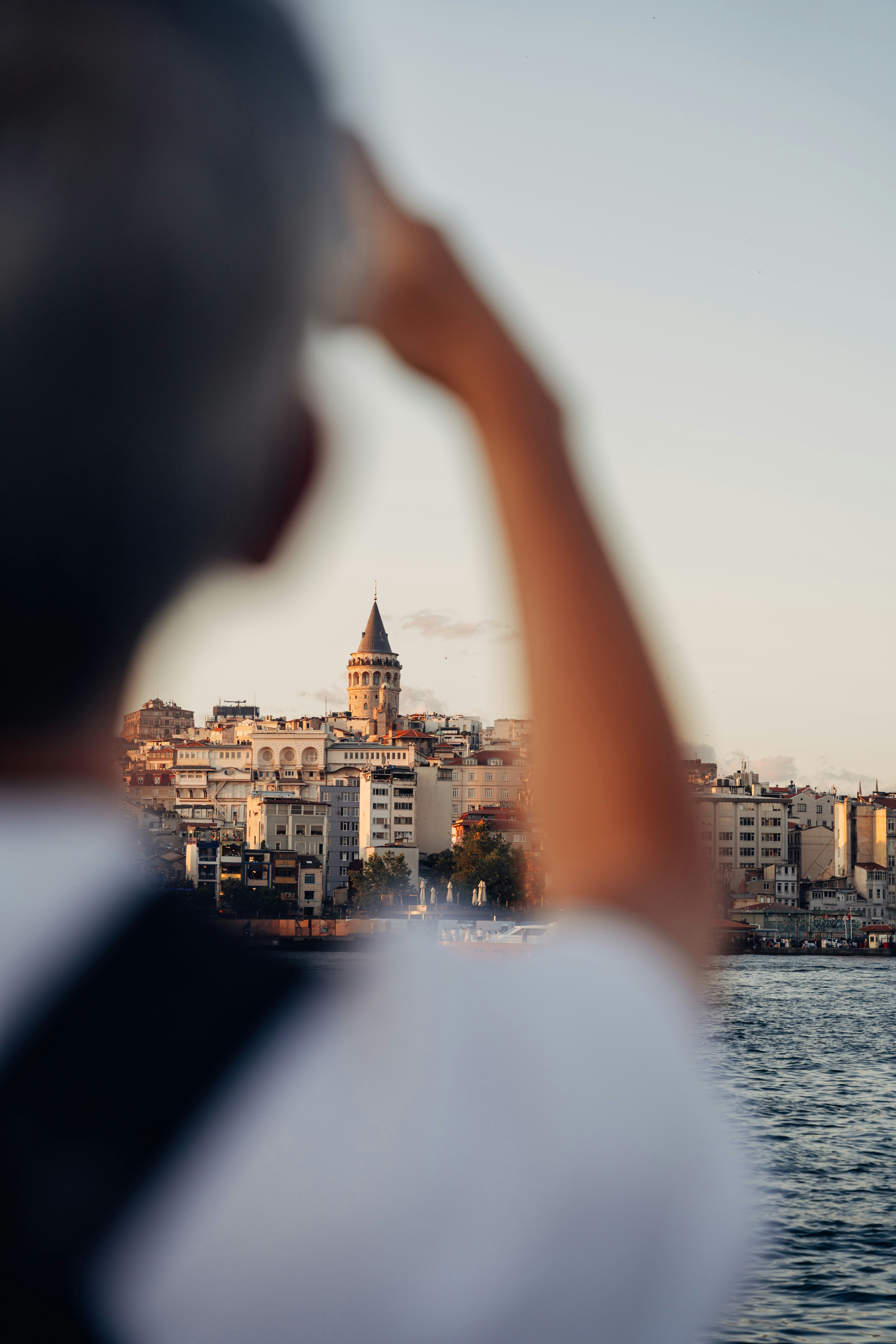 A person looking at the Galata Tower across the water in Istanbul at golden hour - 相关推荐