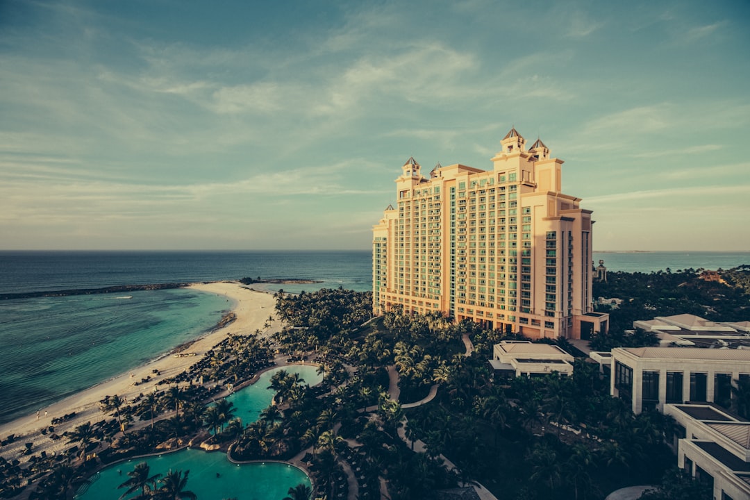 yellow concrete building beside body of water, Hotel resort in sunlight