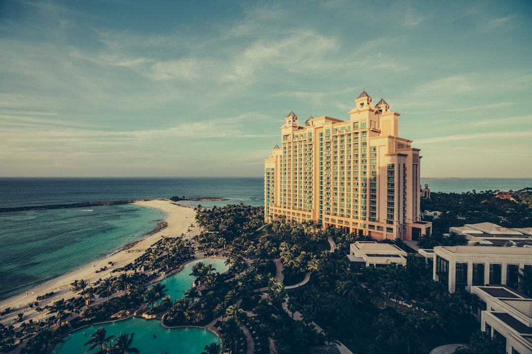 yellow concrete building beside body of water, Hotel resort in sunlight
