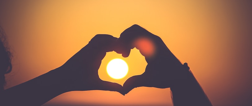 silhouette of person's hands forming heart