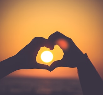 silhouette of person's hands forming heart