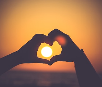 silhouette of person's hands forming heart
