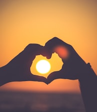silhouette of person's hands forming heart