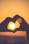 silhouette of person's hands forming heart