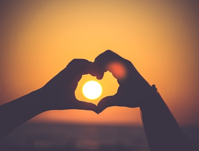 silhouette of person's hands forming heart