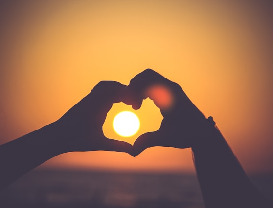 silhouette of person's hands forming heart