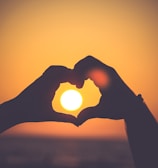 silhouette of person's hands forming heart