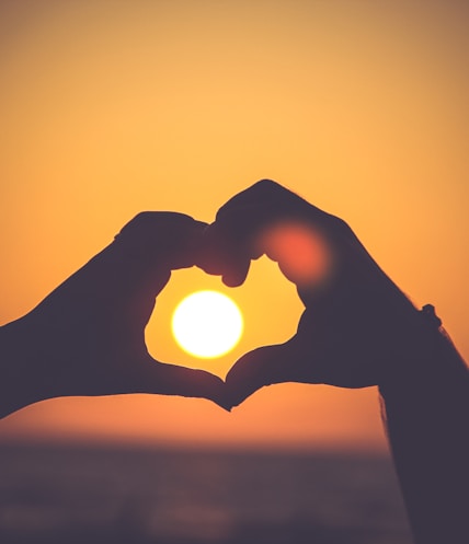 silhouette of person's hands forming heart