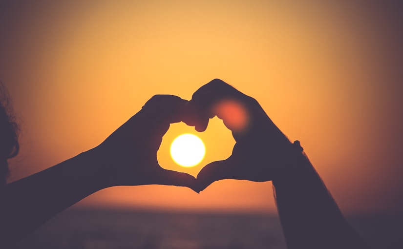 silhouette of person's hands forming heart