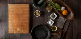 black mortar and pestle beside brown box in top view photography
